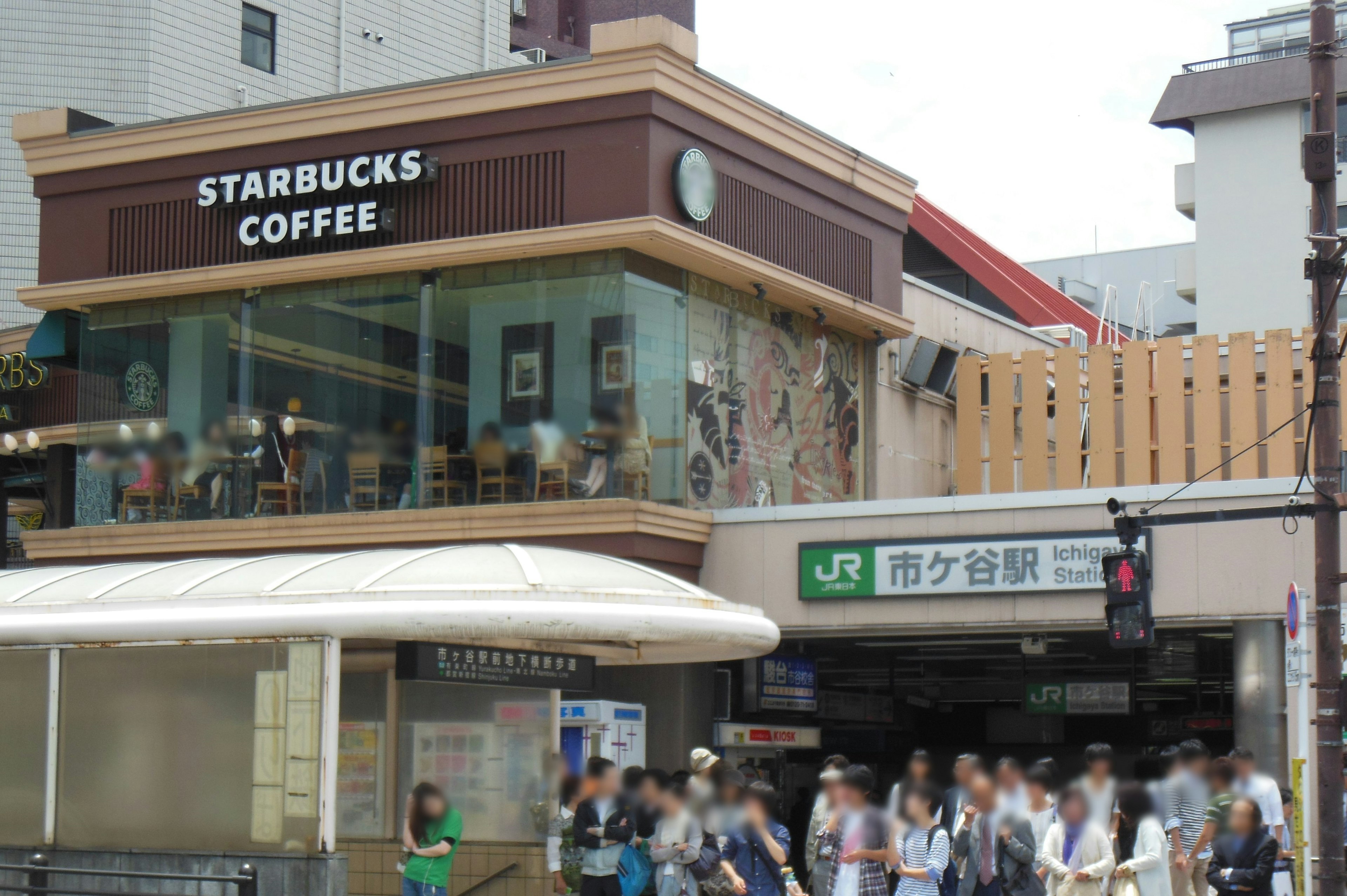 Imagen de una tienda Starbucks Coffee y la entrada de una estación de tren