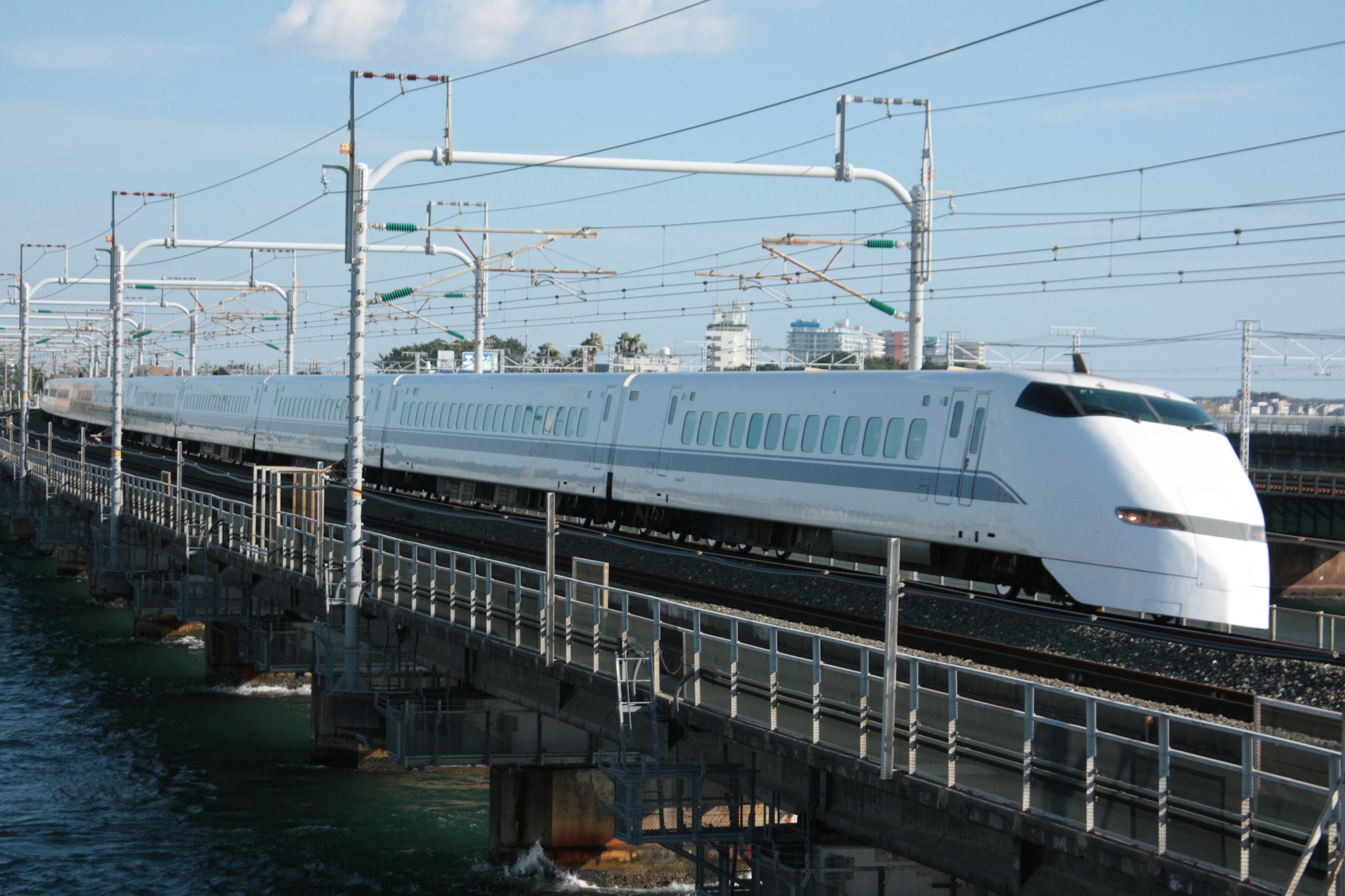 Treno Shinkansen bianco che attraversa un ponte