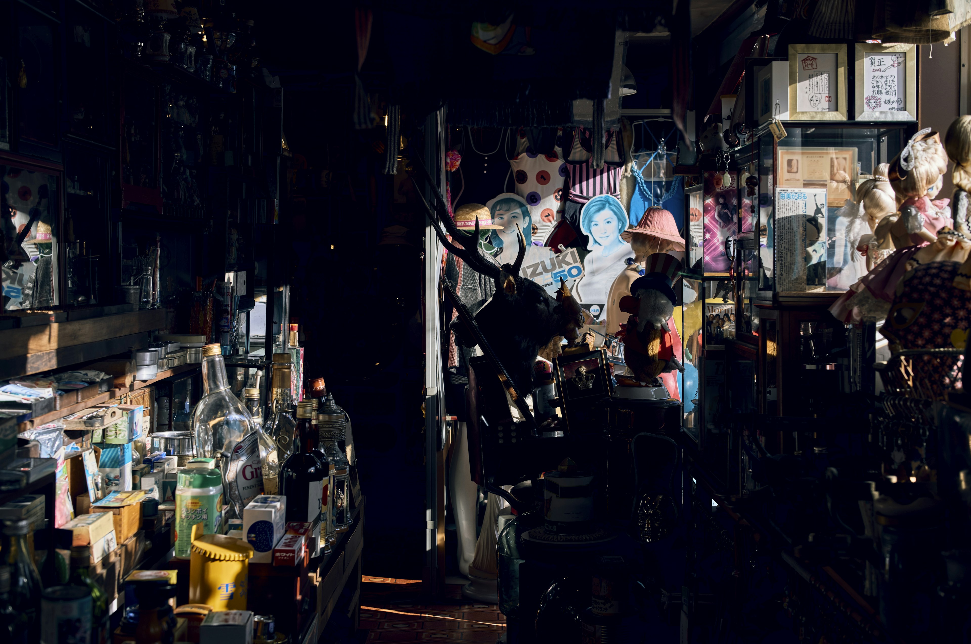 Interior de una tienda vintage desordenada con varios objetos y poca luz