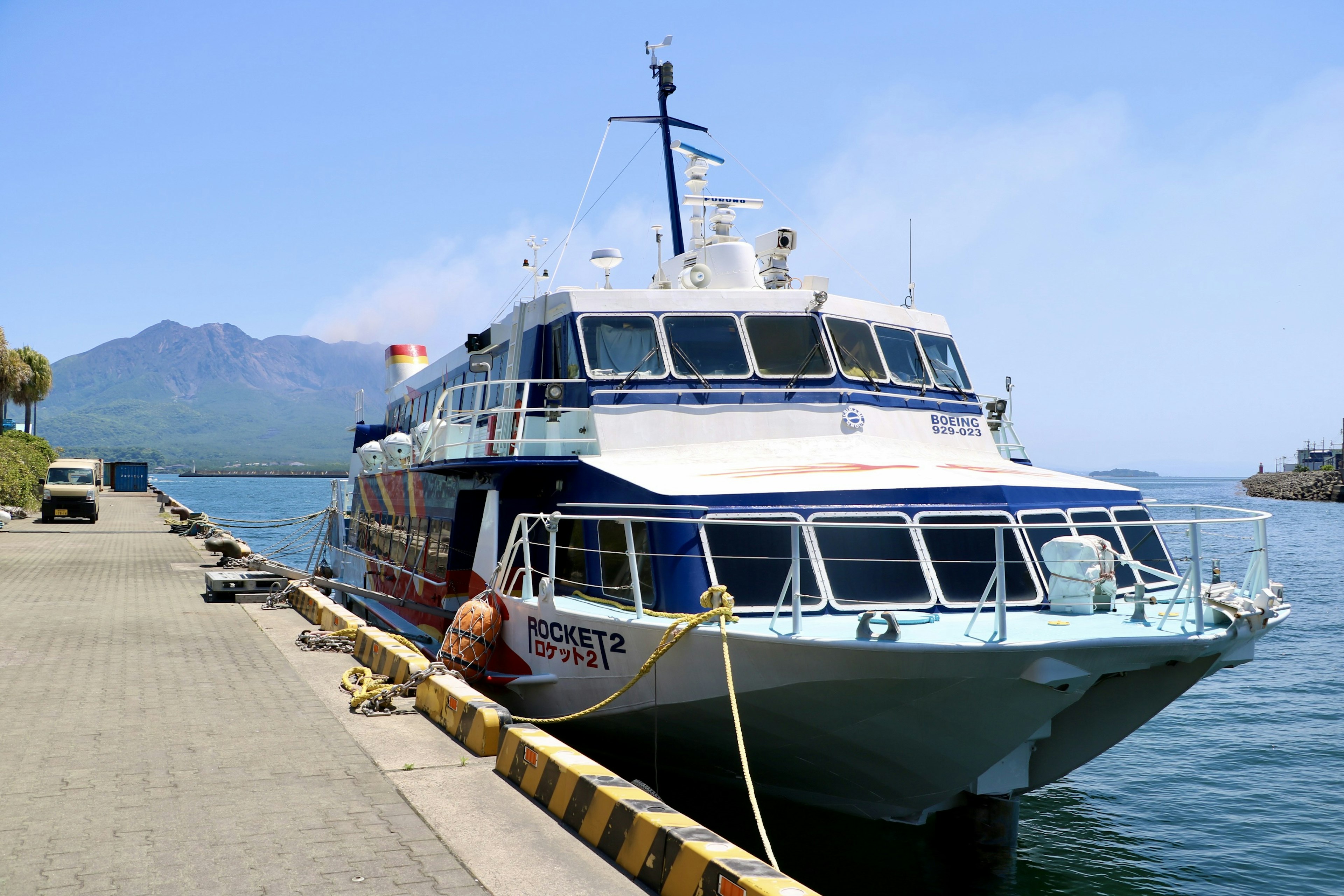 Ferry đầy màu sắc đậu tại cảng với núi ở phía sau