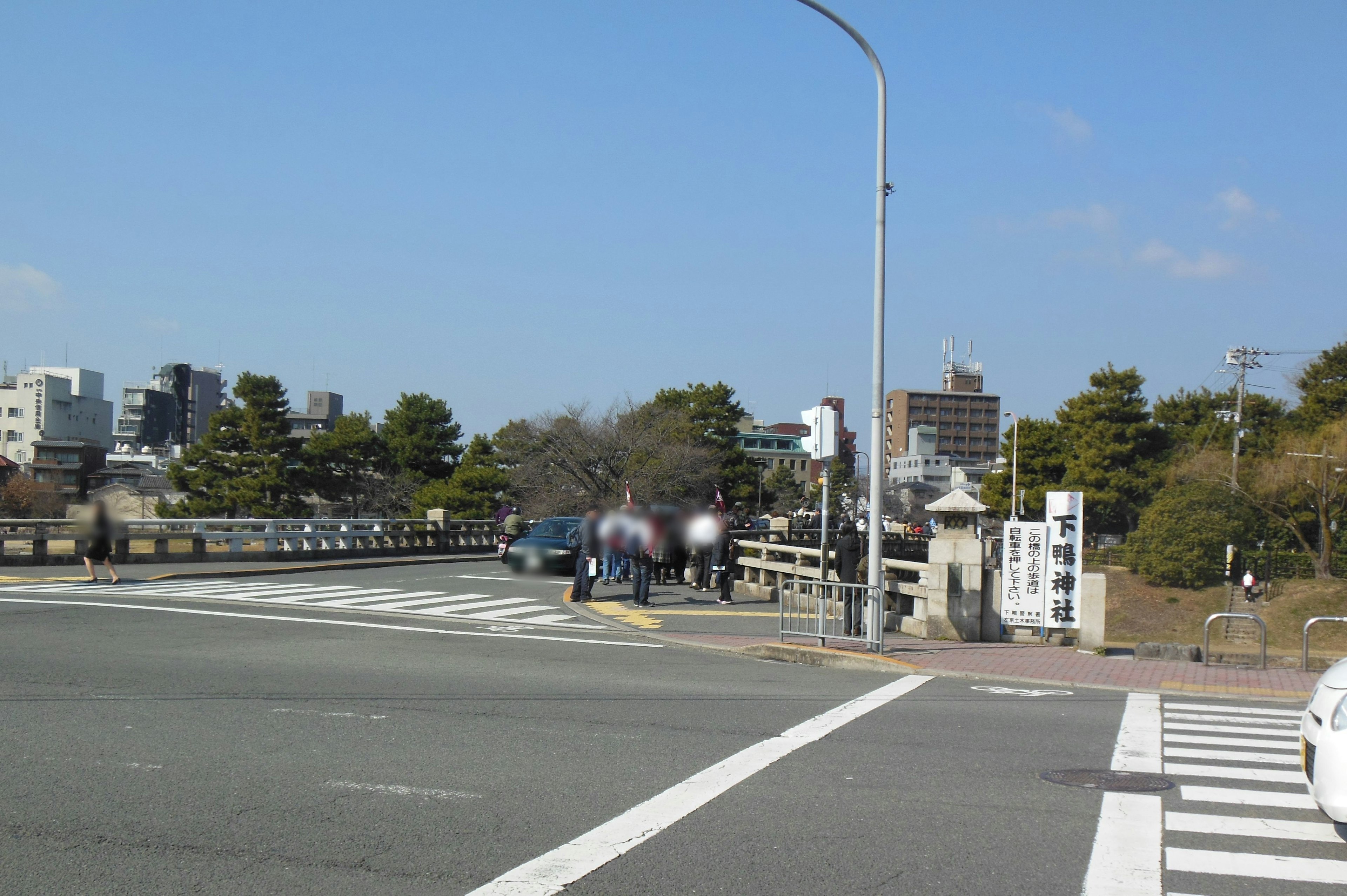 Brücke und Stadtlandschaft unter blauem Himmel mit Autos und Fußgängern