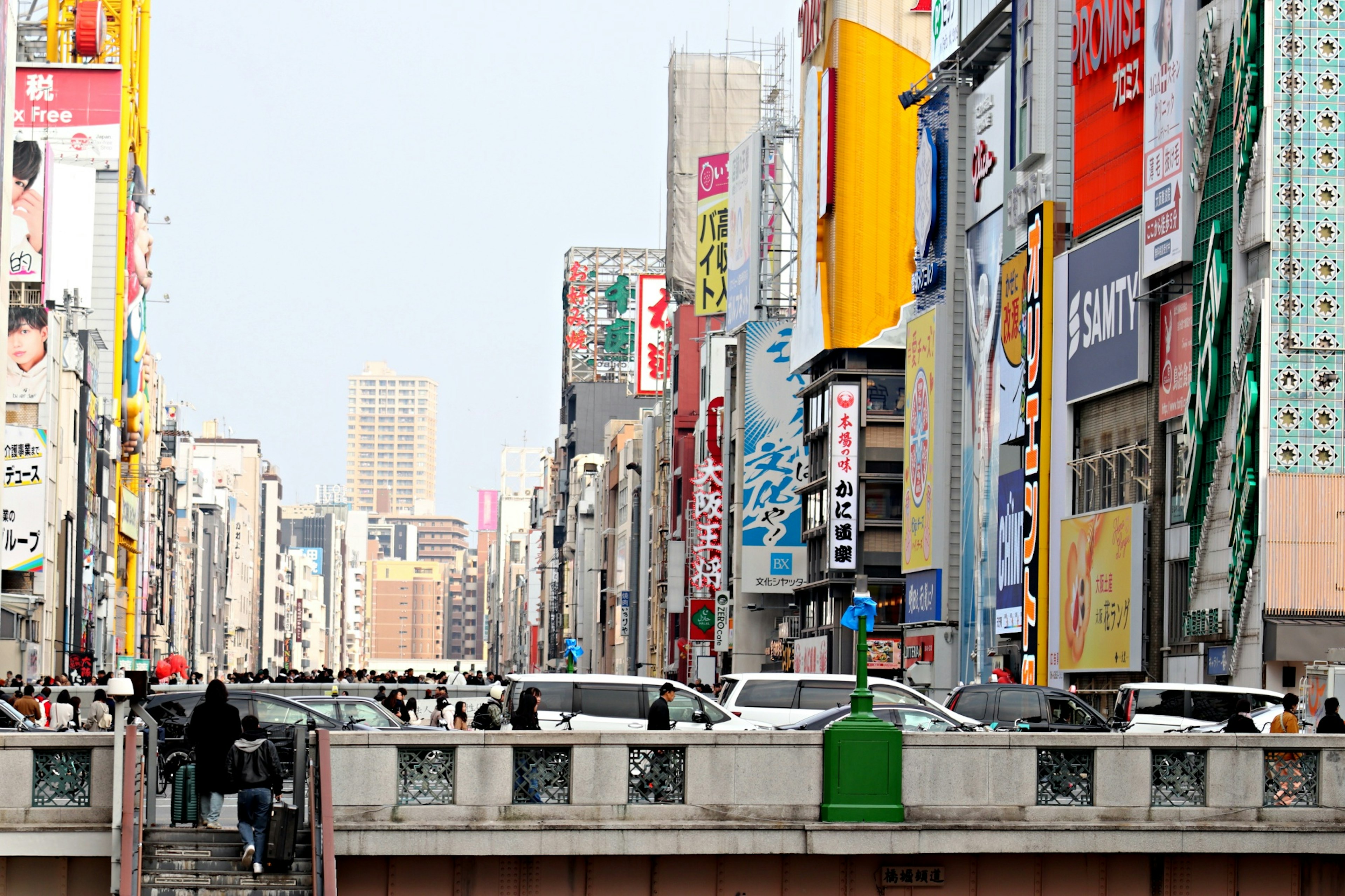 Strada affollata ad Akihabara con insegne colorate e traffico