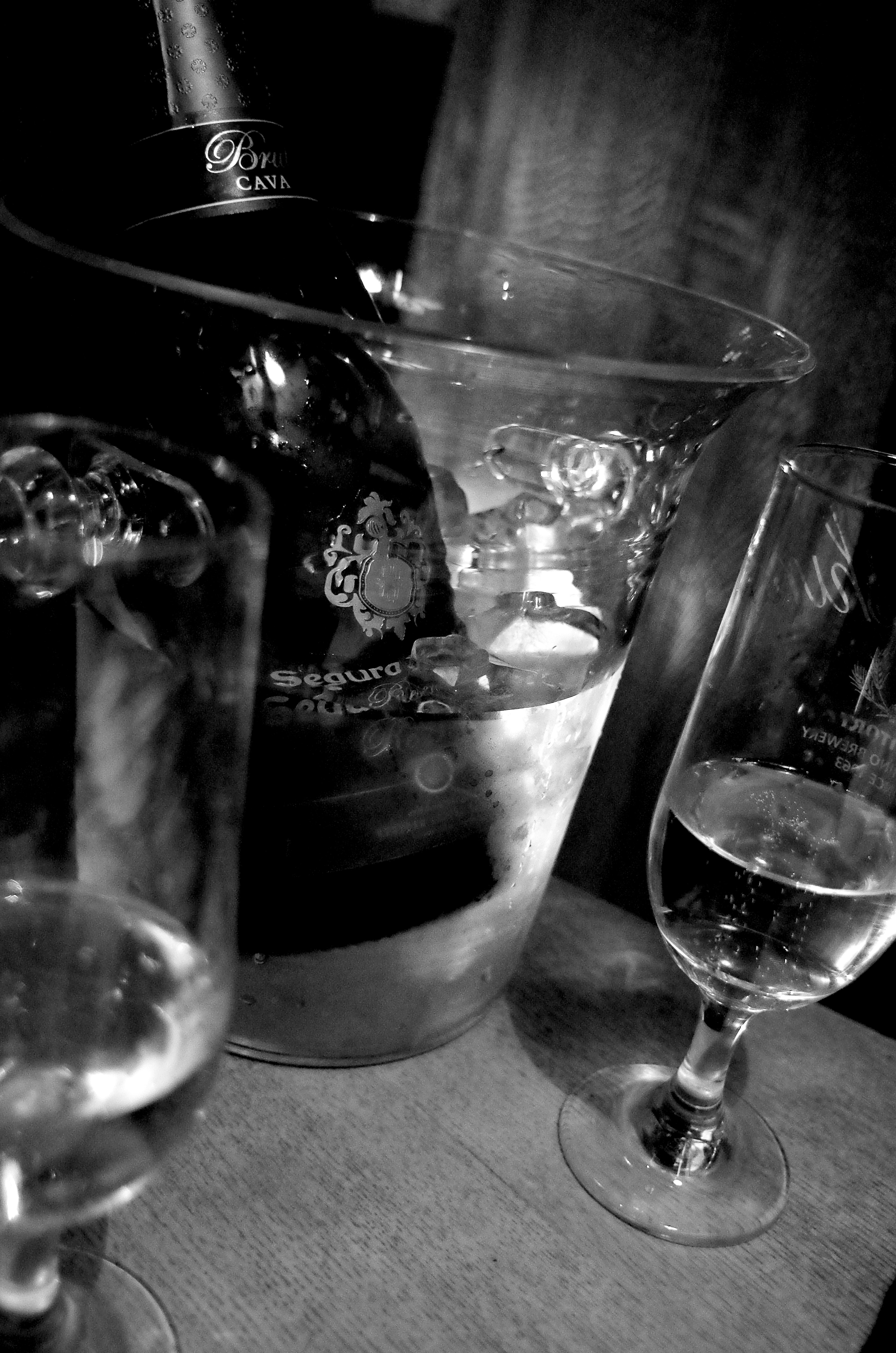 Black and white image of a champagne cooler and champagne glasses