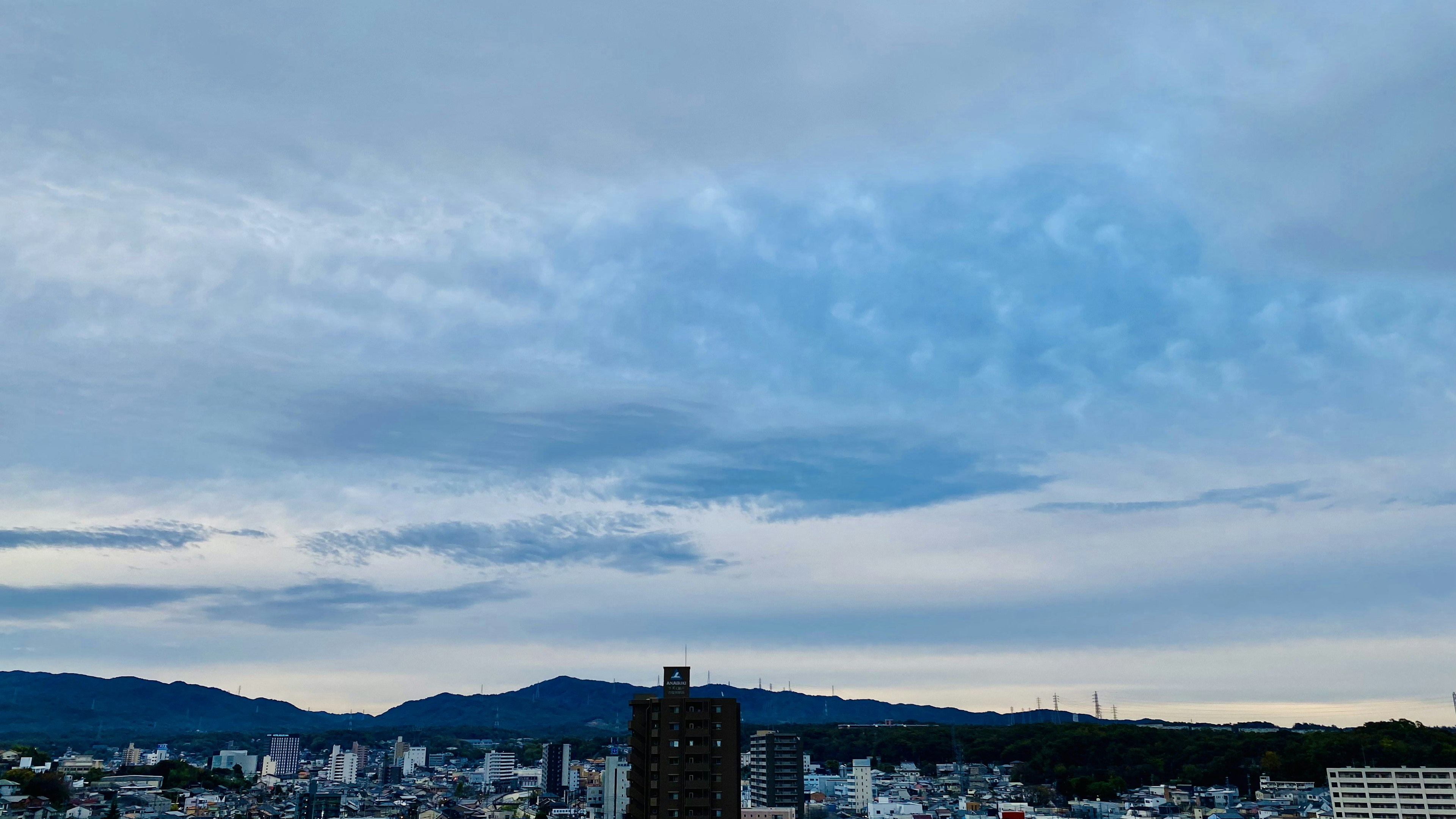 Paesaggio urbano con cielo blu e nuvole edifici alti e montagne