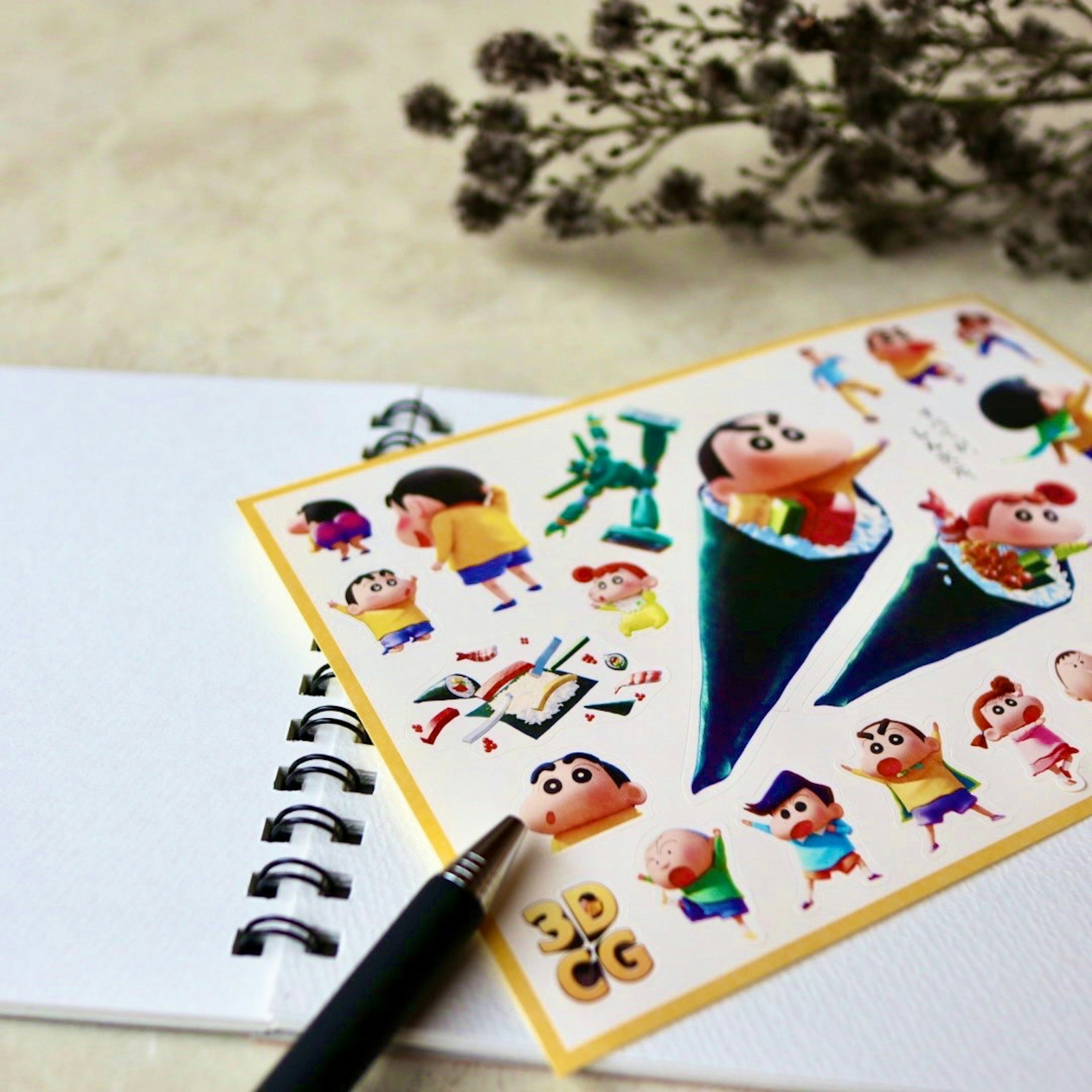 Colorful sticker sheet placed on a white notebook with a pen