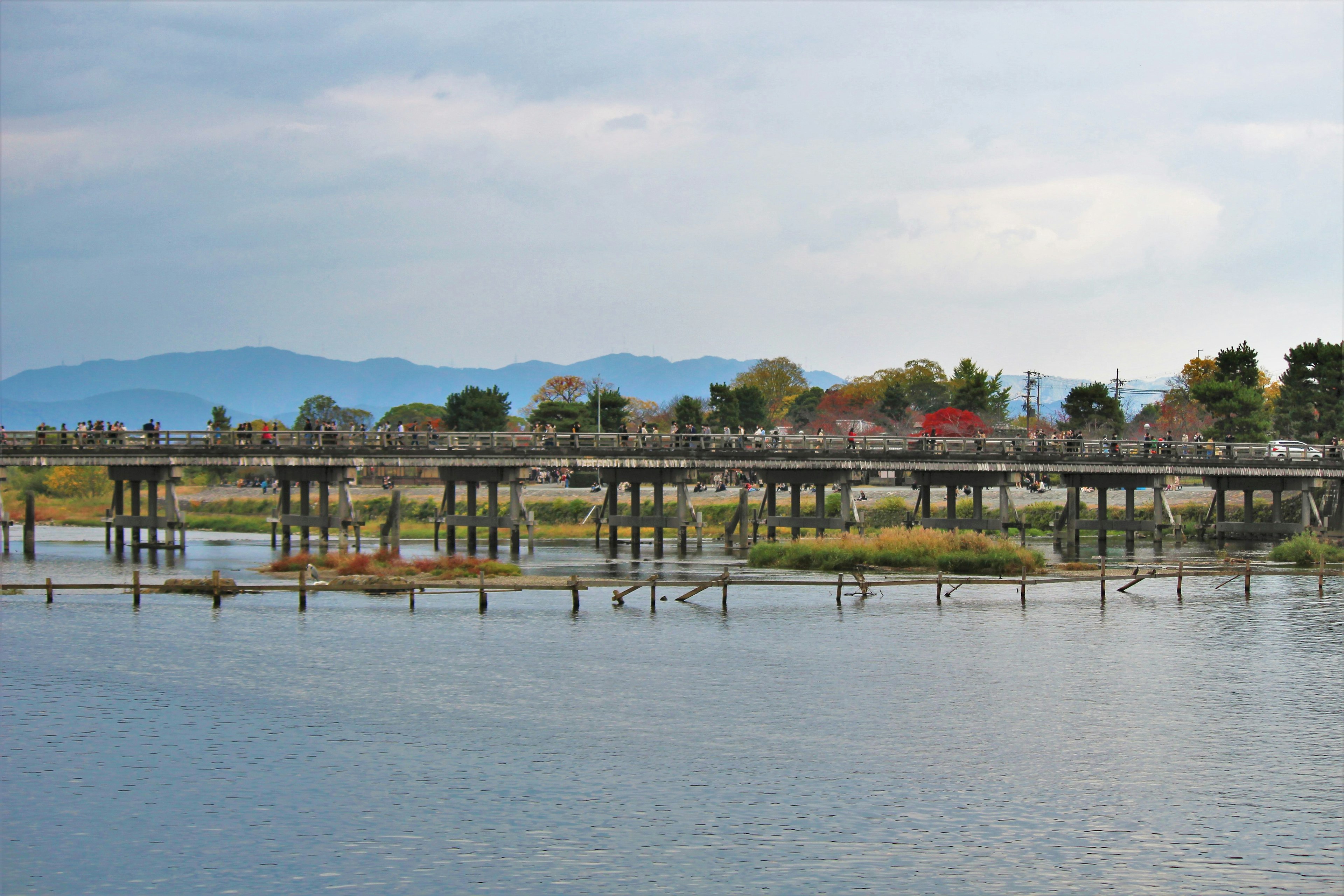 Ponte in legno che si riflette sull'acqua calma con il paesaggio circostante