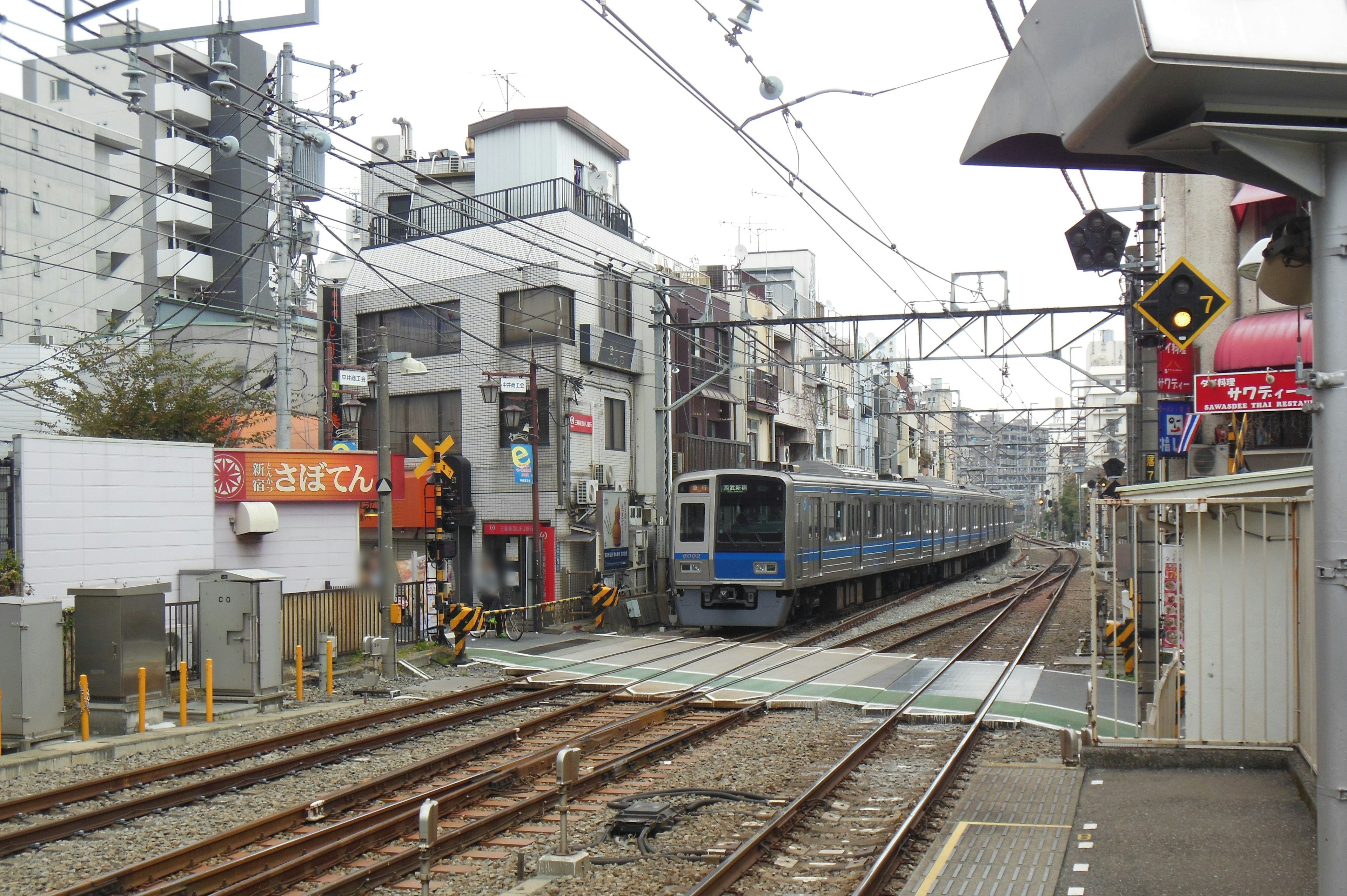 Train passing through a station with surrounding buildings