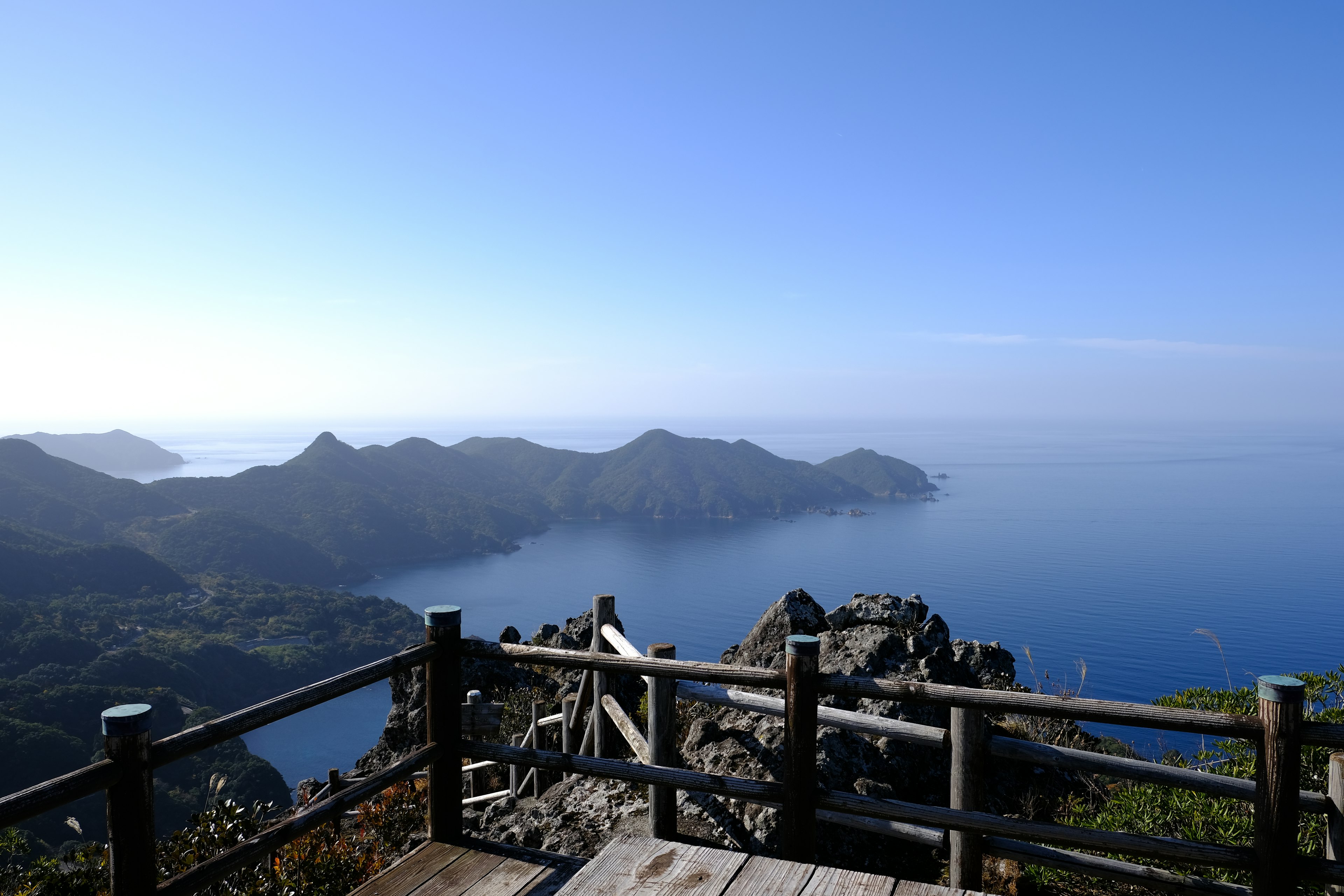 Vue panoramique depuis un point de vue montagneux avec océan bleu et îles lointaines