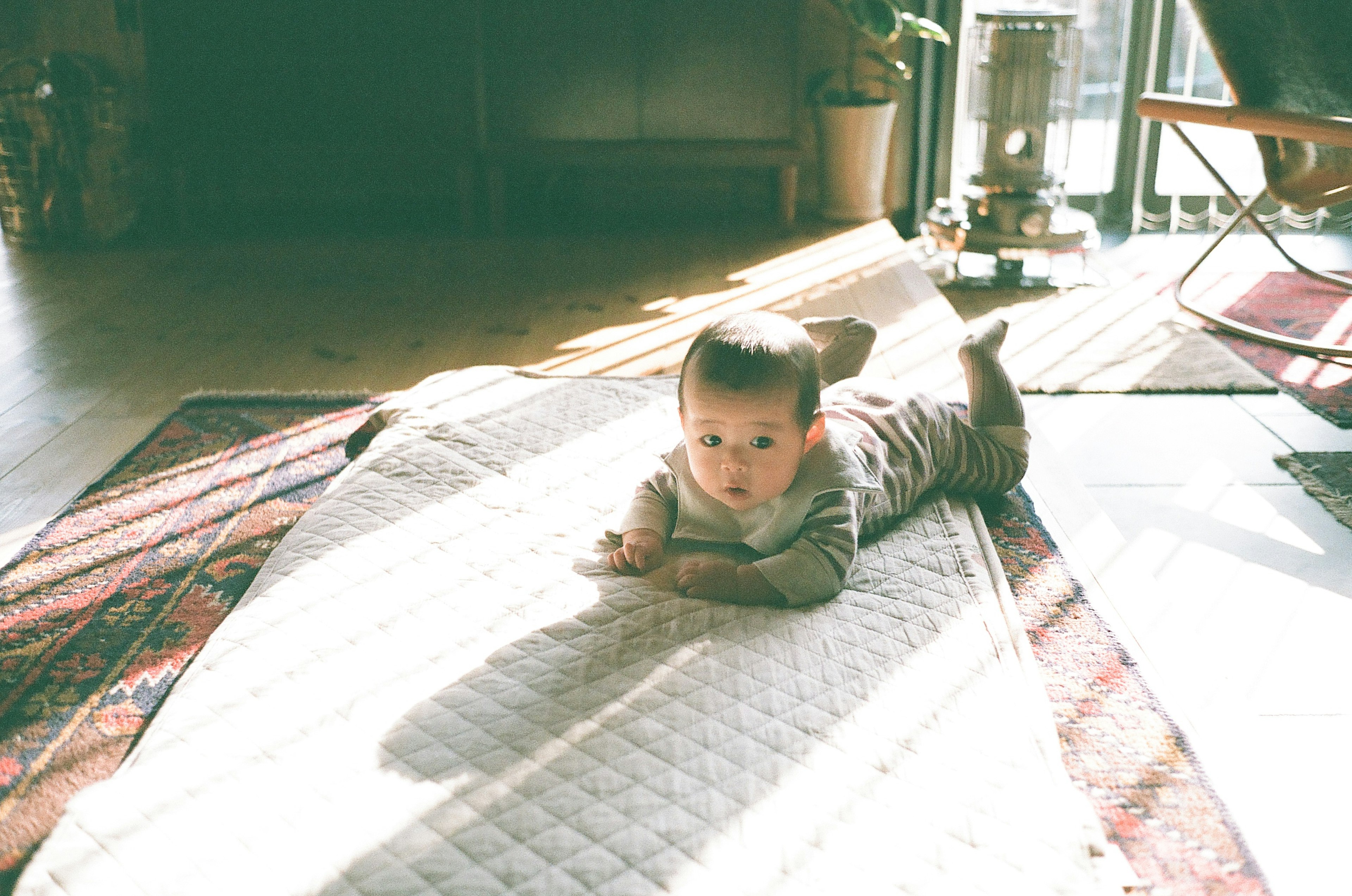 Baby lying on a soft mat in a bright indoor setting