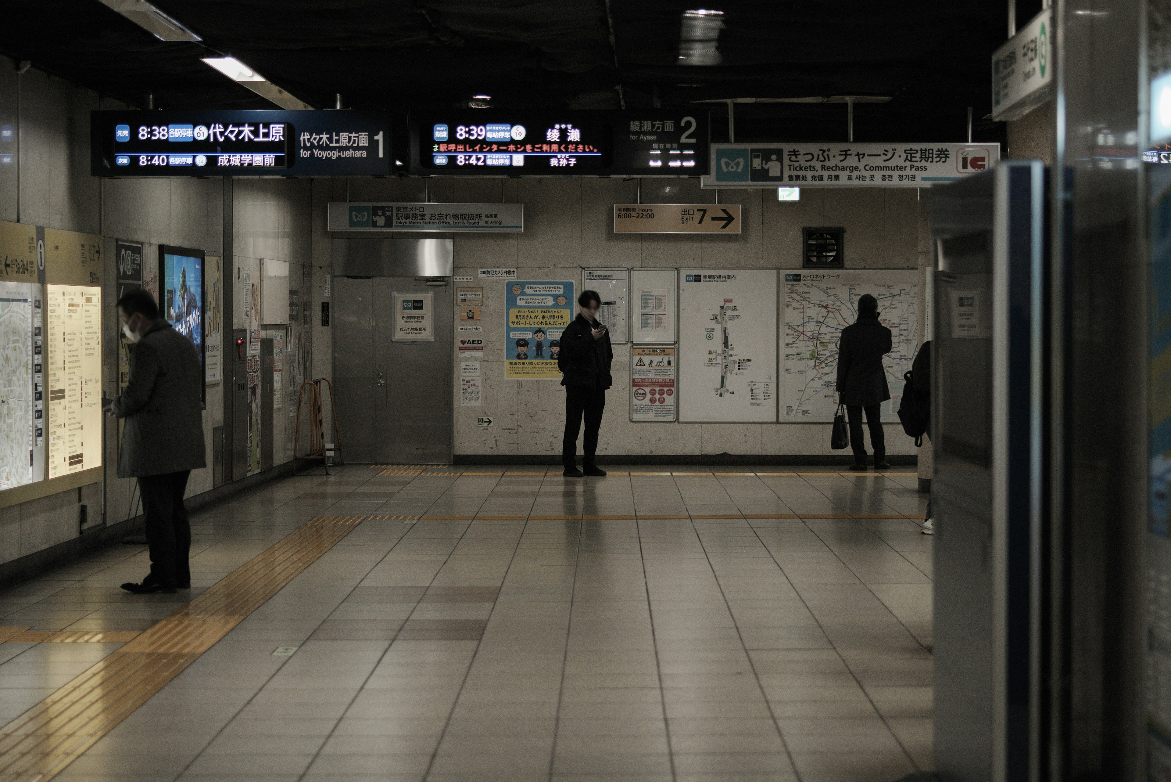 Ruhiges Innere einer U-Bahn-Station mit Menschen und Beschilderung