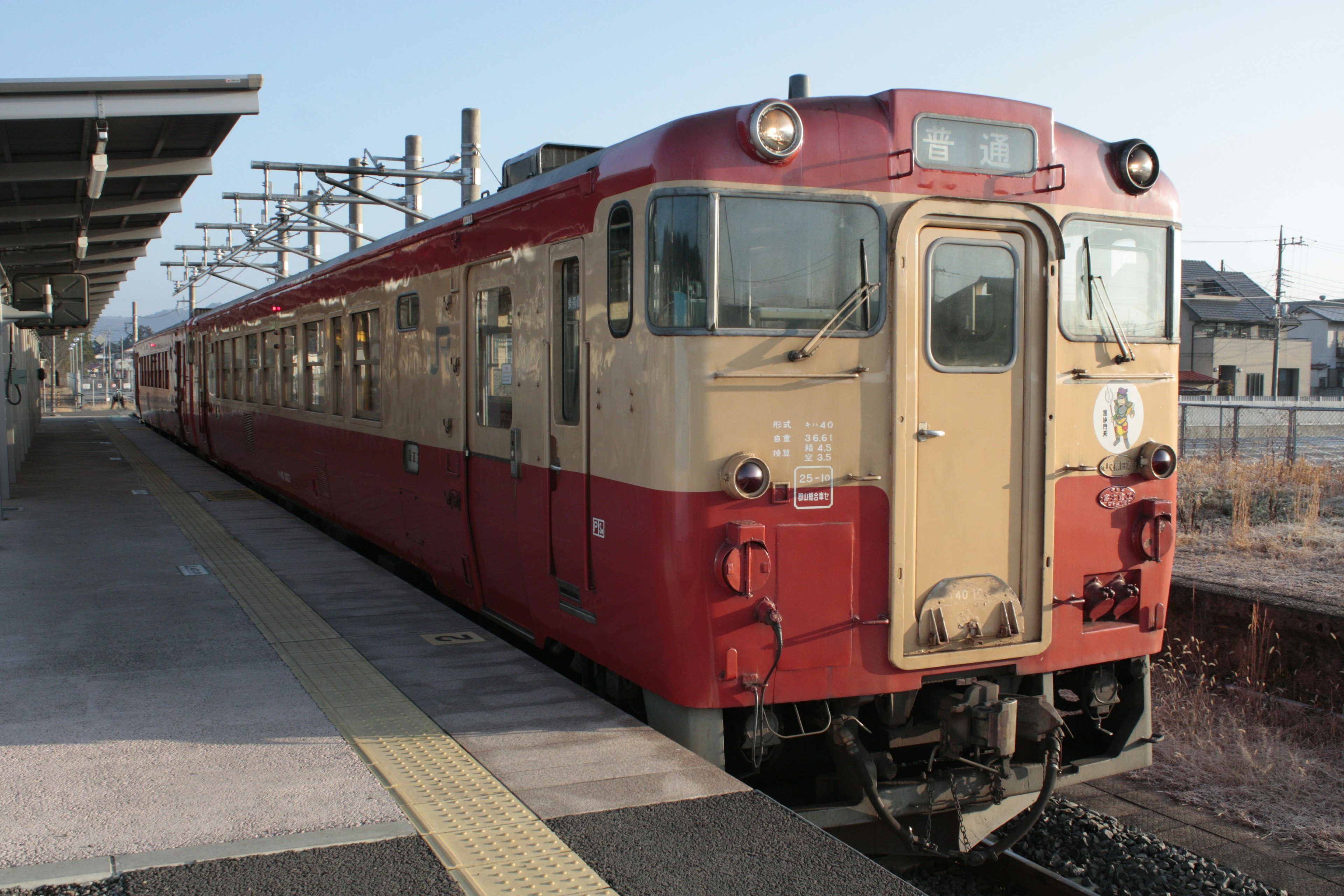 赤とクリーム色の電車が駅に停車中