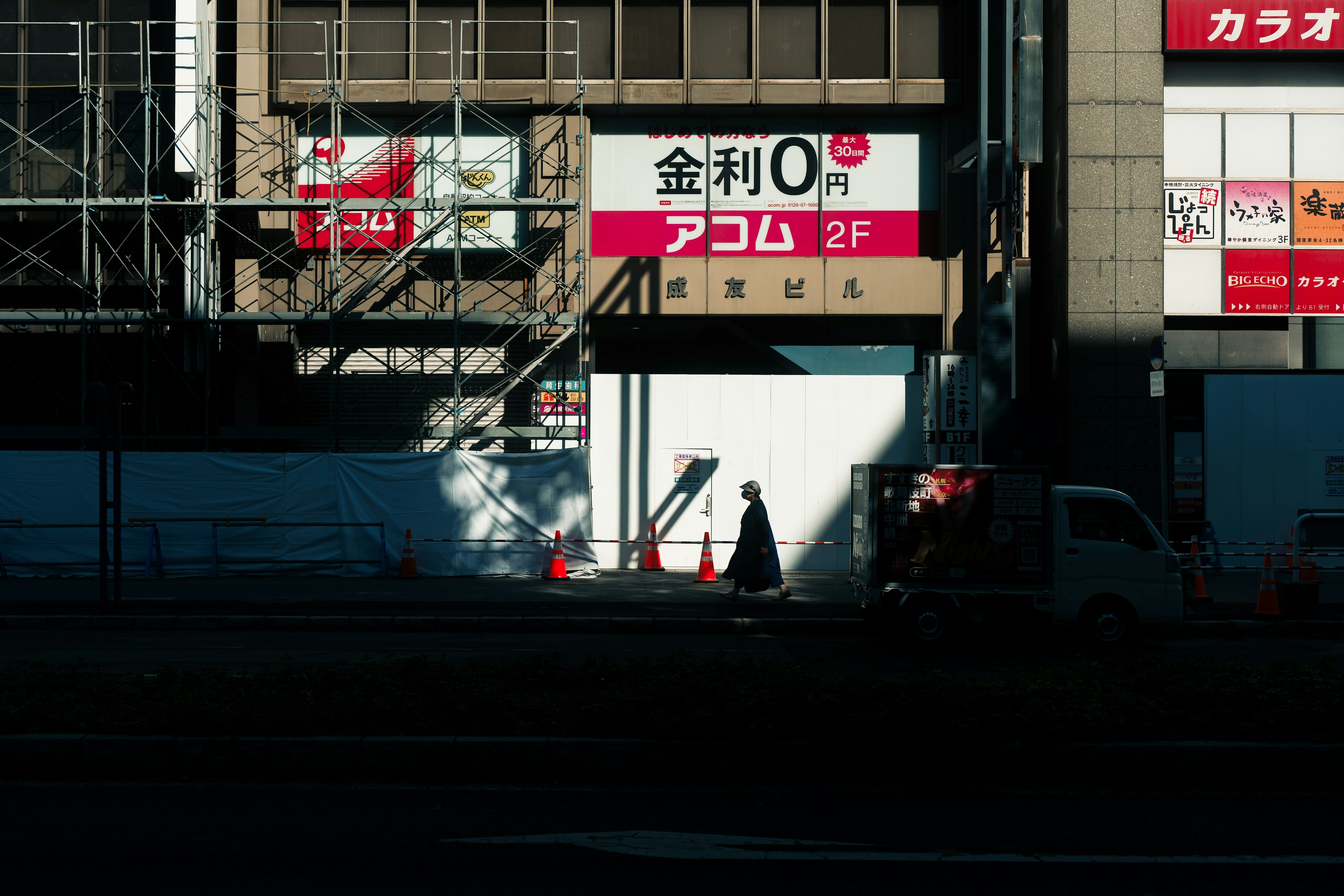 建物の外観と看板が写った画像、階段と影が特徴的