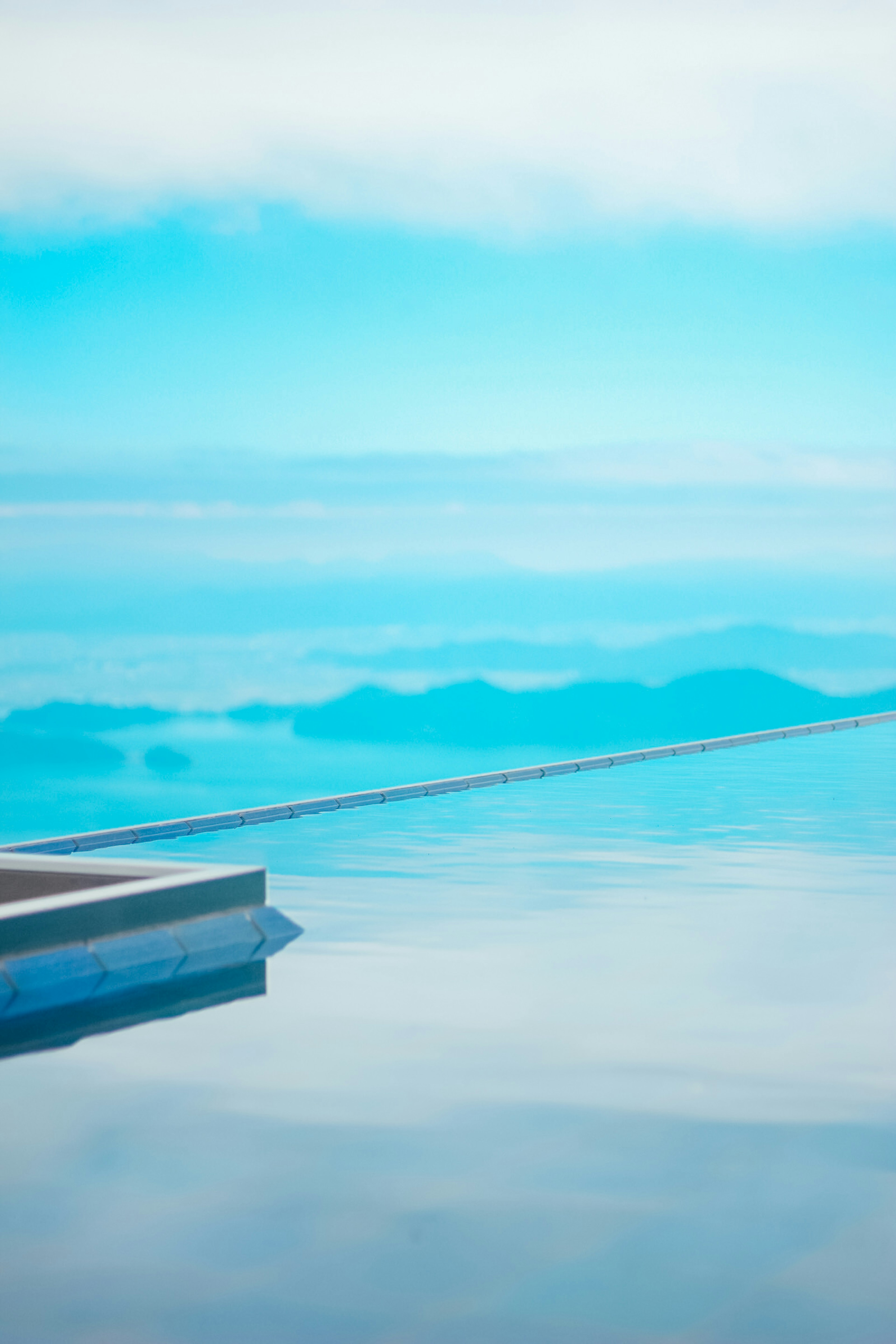 Piscine à débordement surplombant des montagnes et un ciel bleu