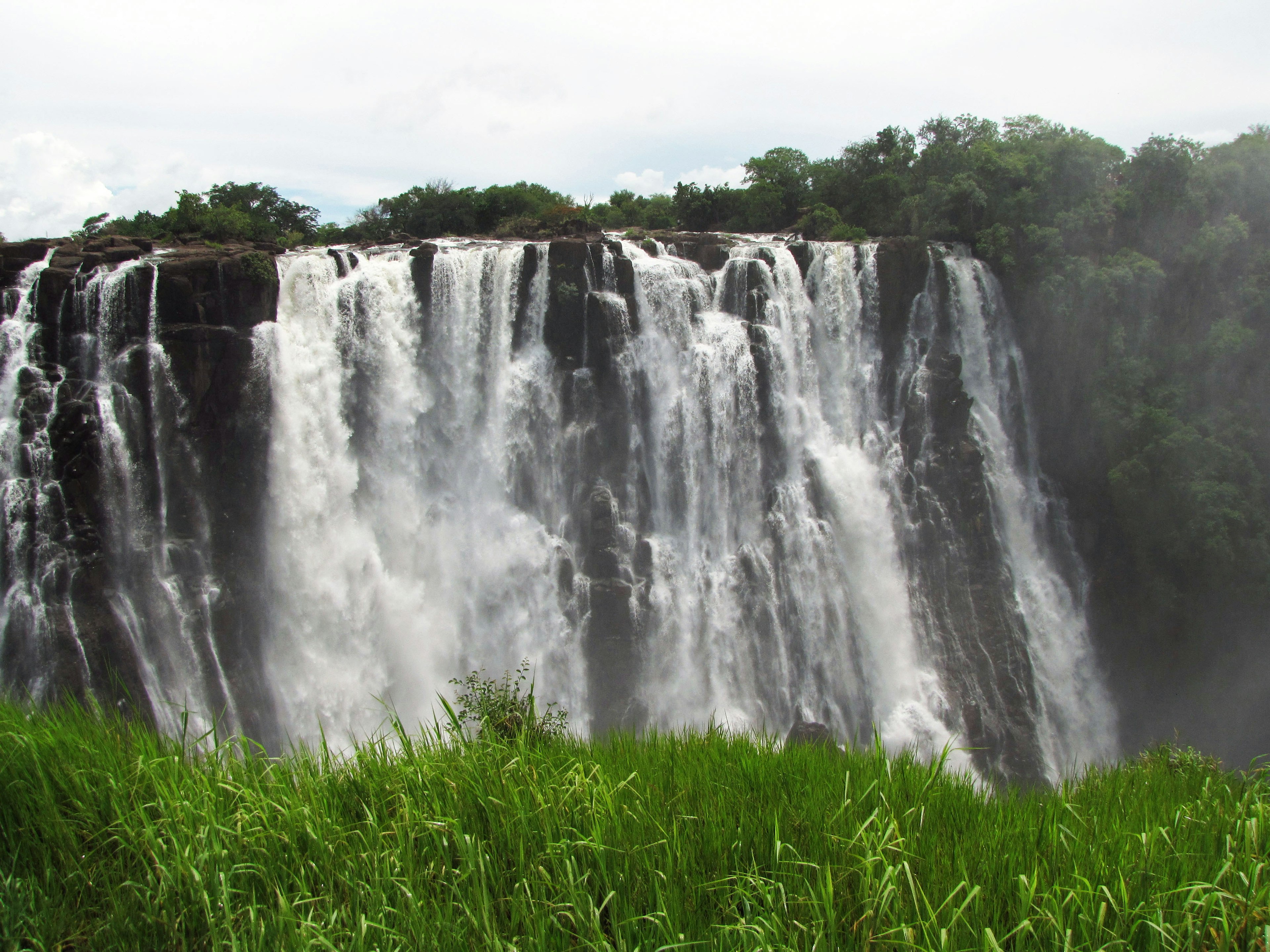 Majestic waterfall cascading over cliffs surrounded by lush greenery