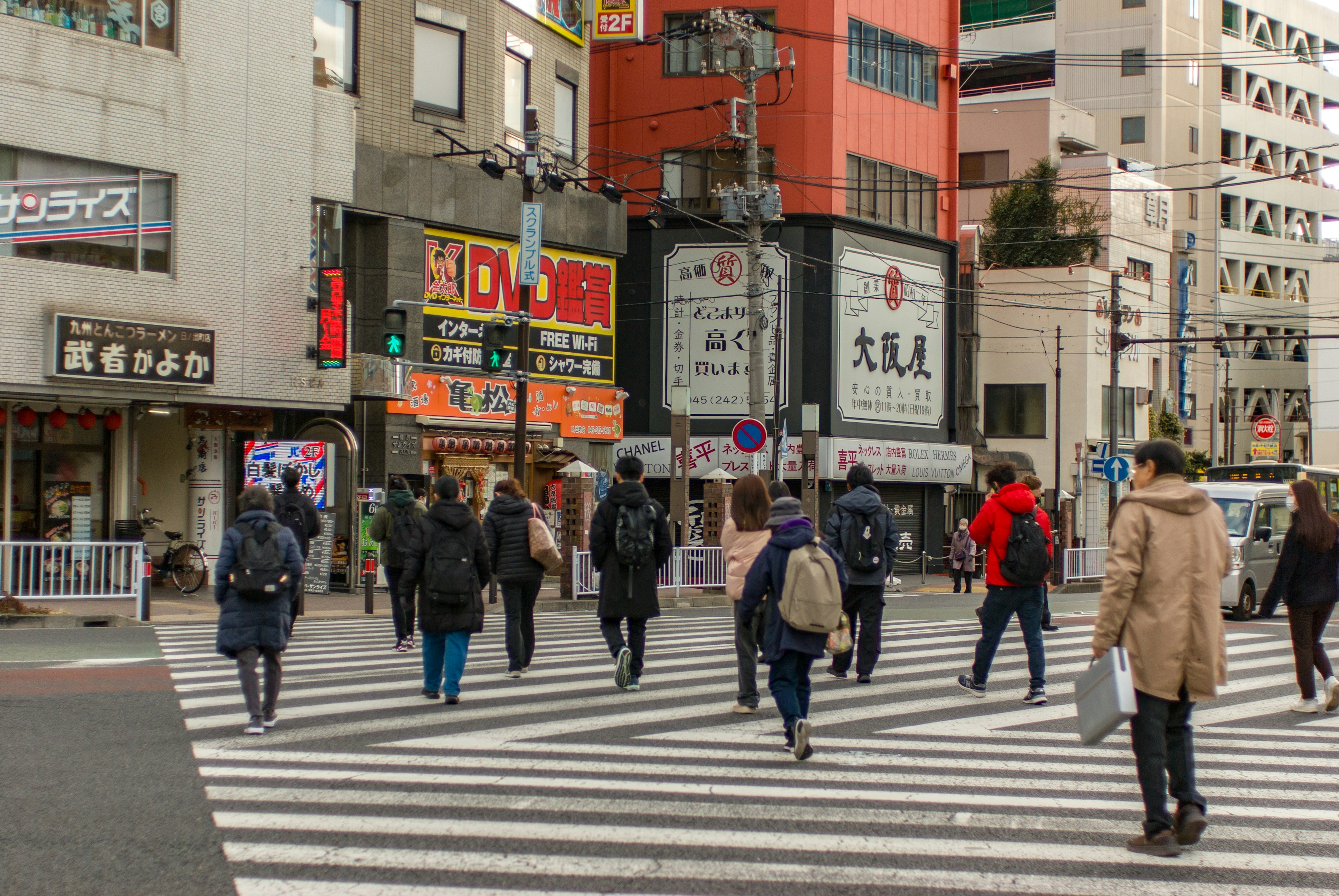 交差点で歩く人々と建物が見える都市の風景