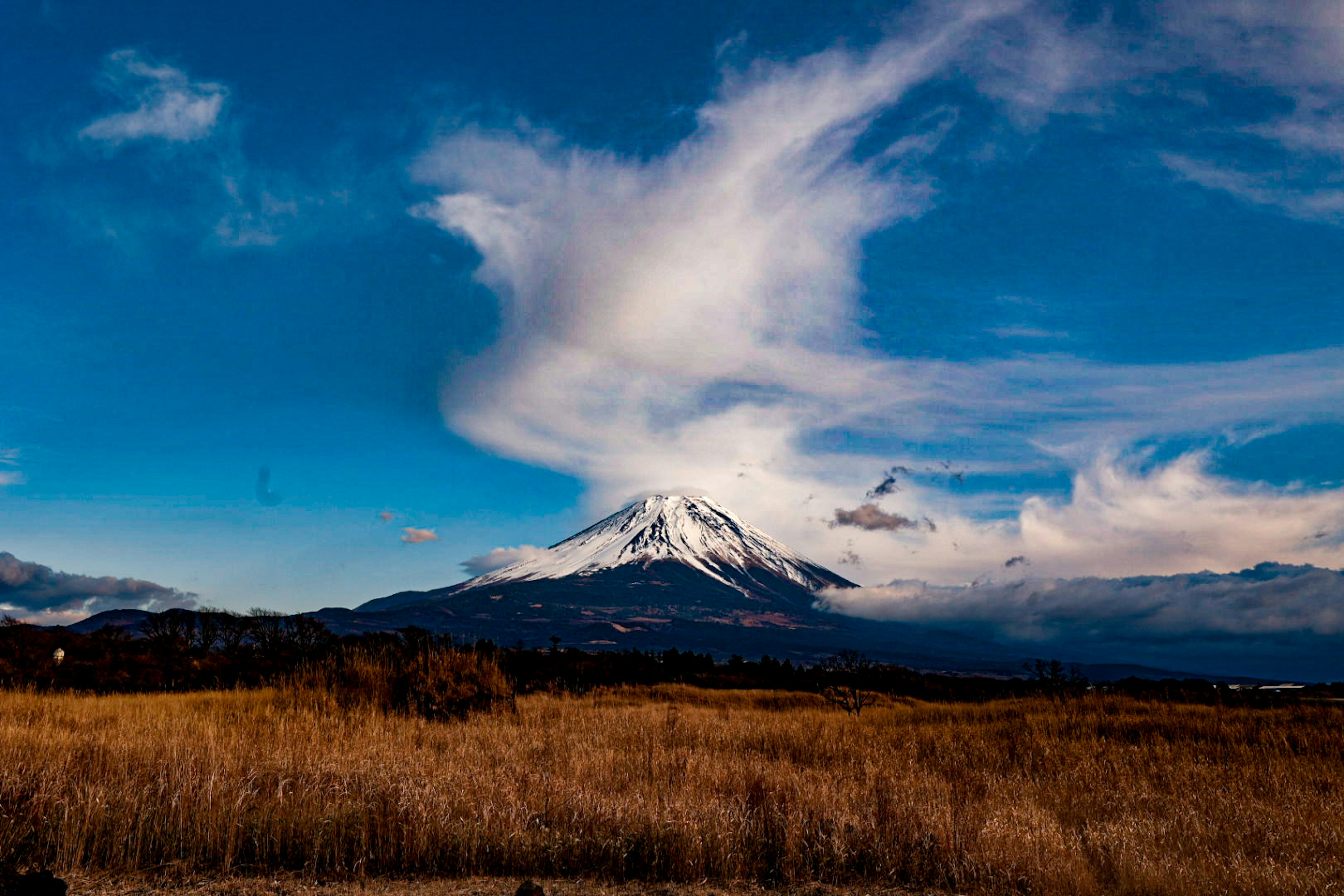 雪をかぶった山と青い空に広がる雲の風景