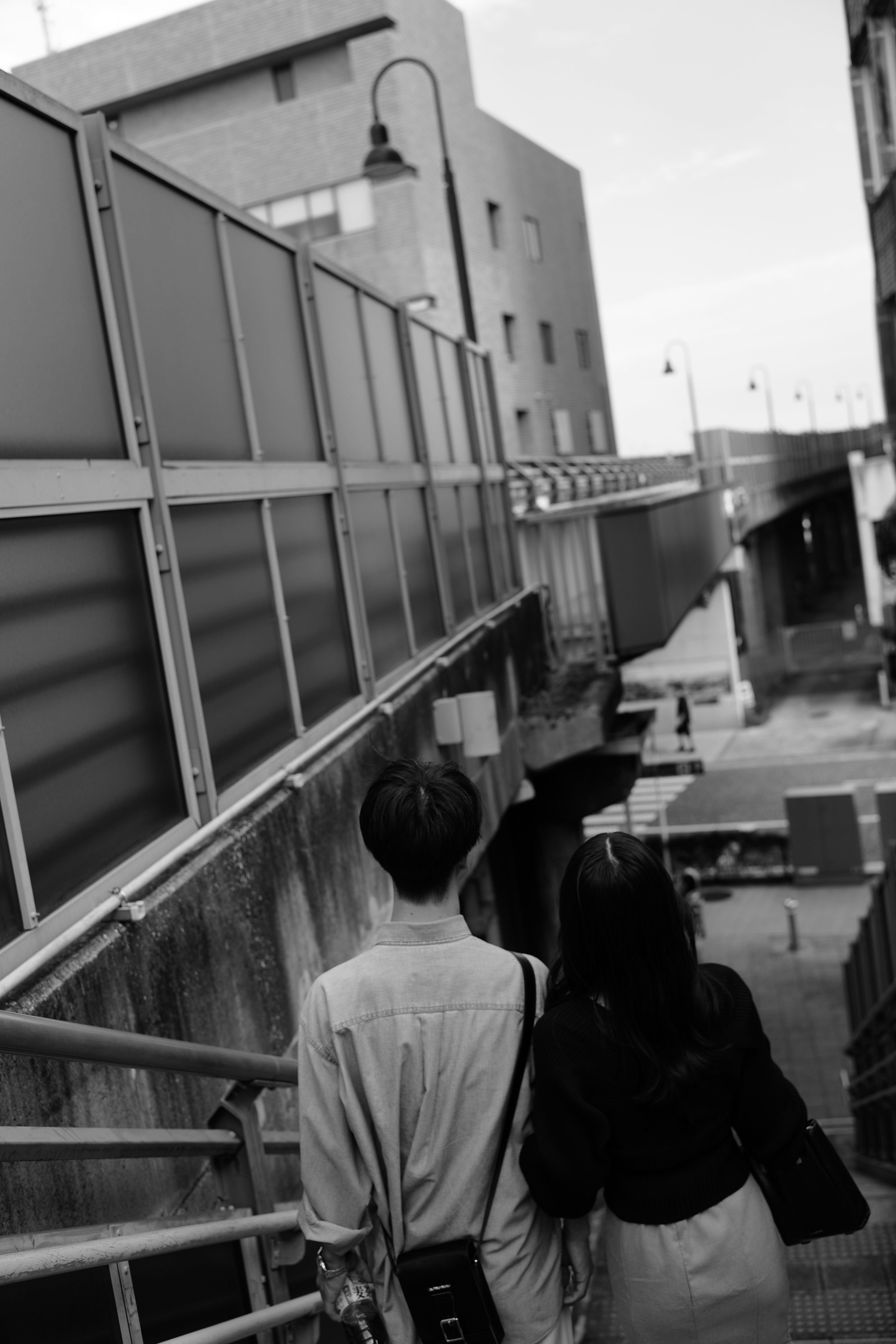 Couple marchant main dans la main dans une scène urbaine en noir et blanc