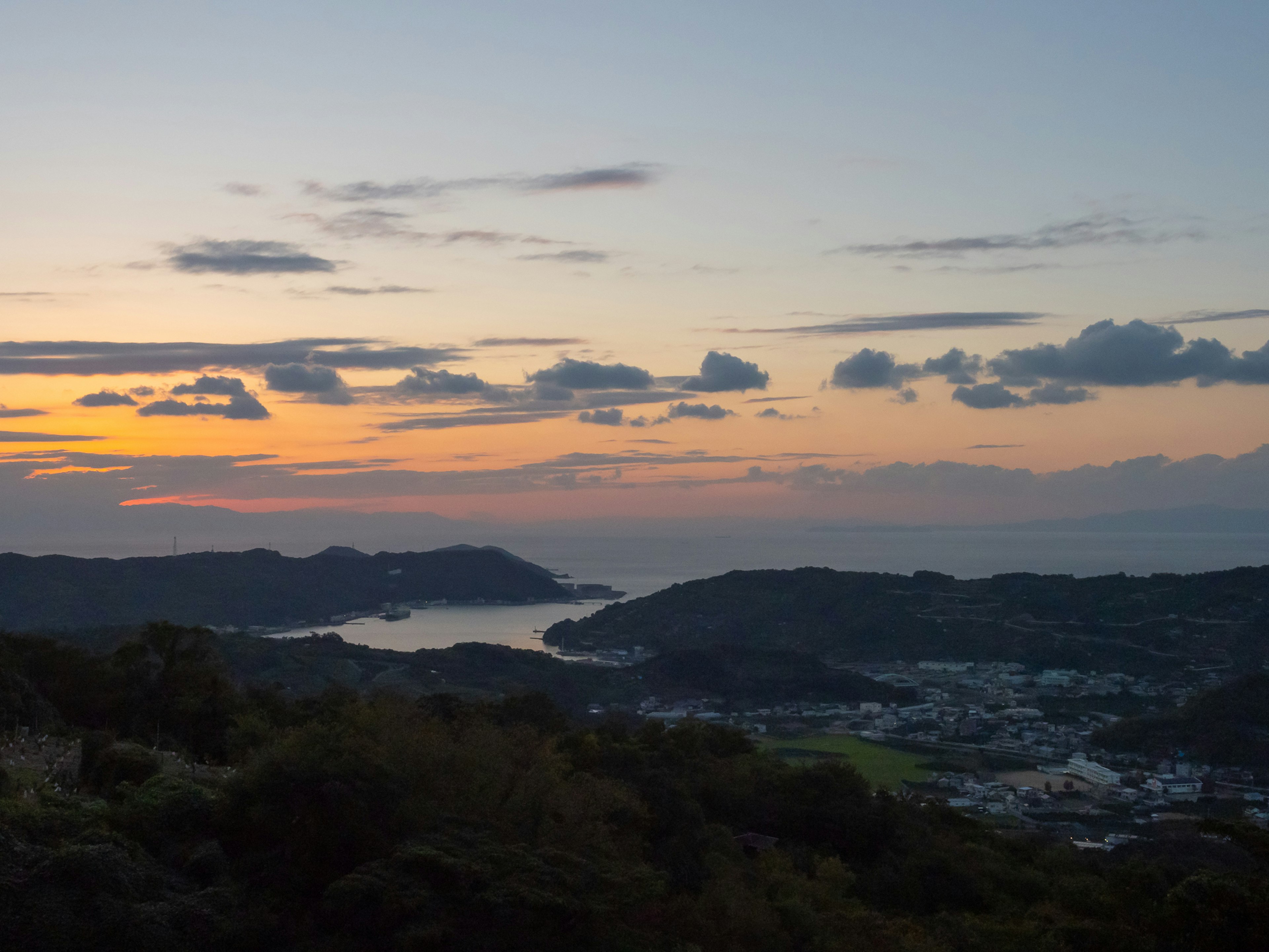 Paysage magnifique avec un coucher de soleil sur la mer et les collines