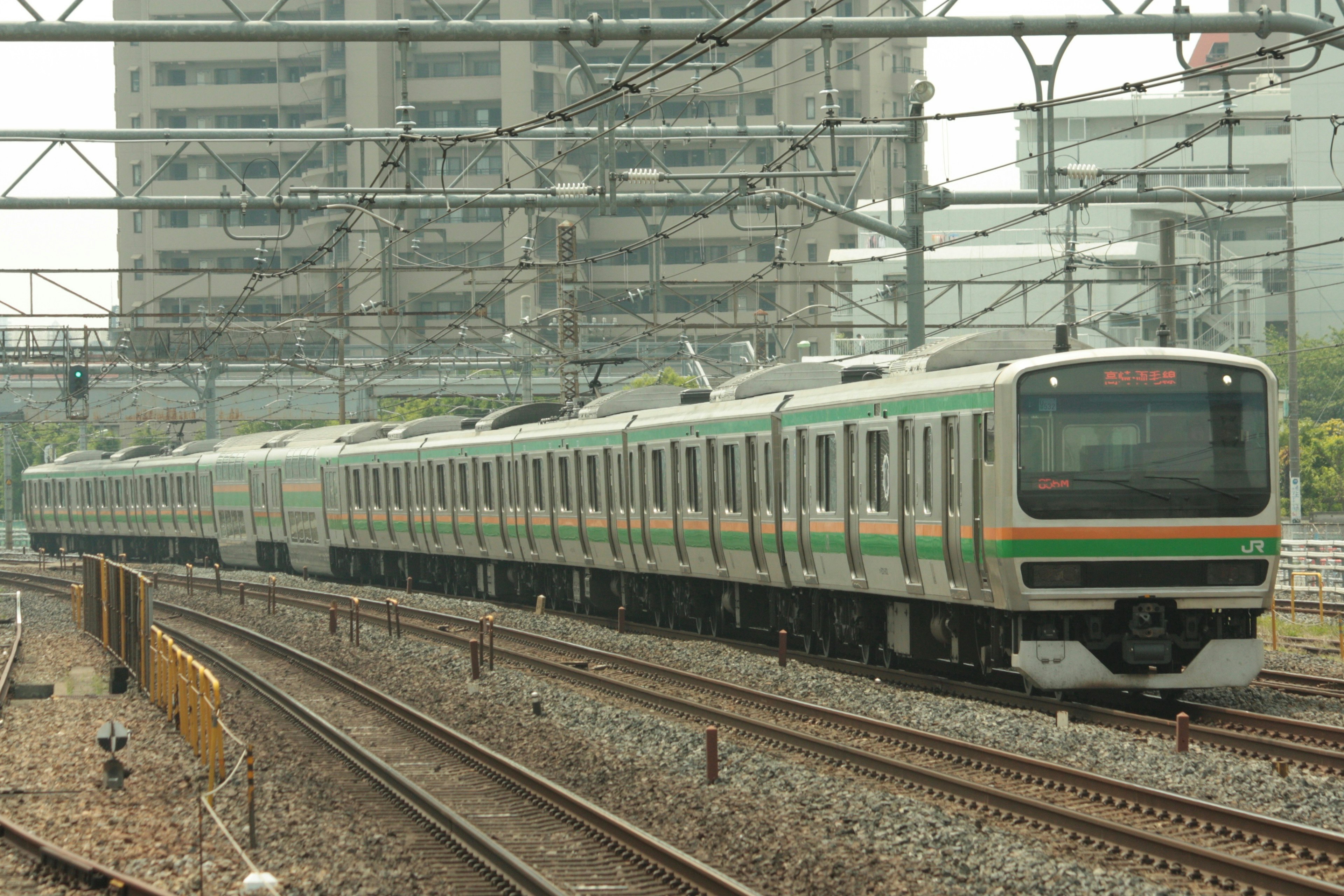 緑と灰色の電車が都市の背景で走行中