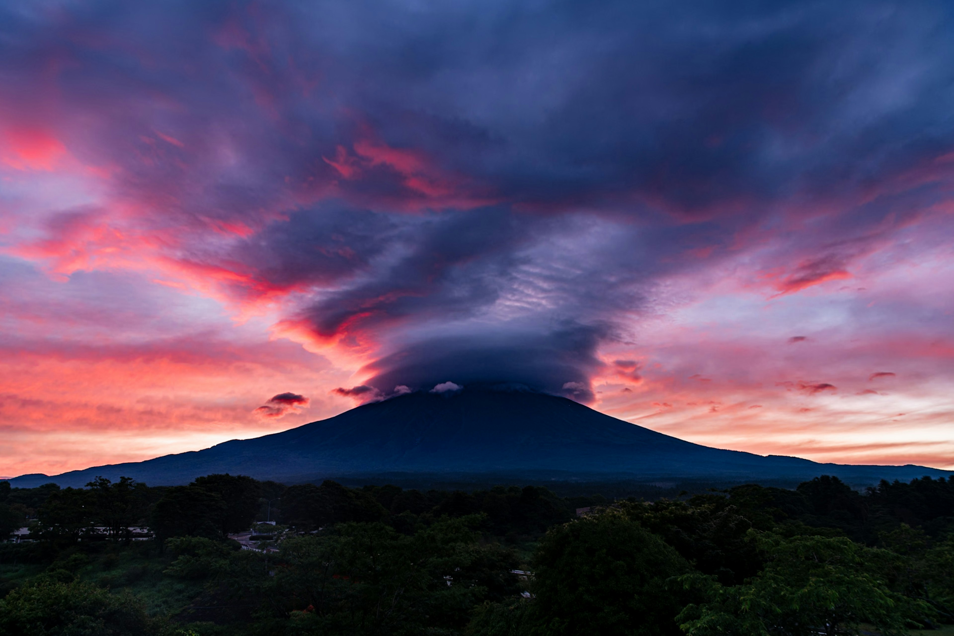 Majestätischer Vulkan unter einem farbenfrohen Sonnenuntergang mit dramatischen Wolken