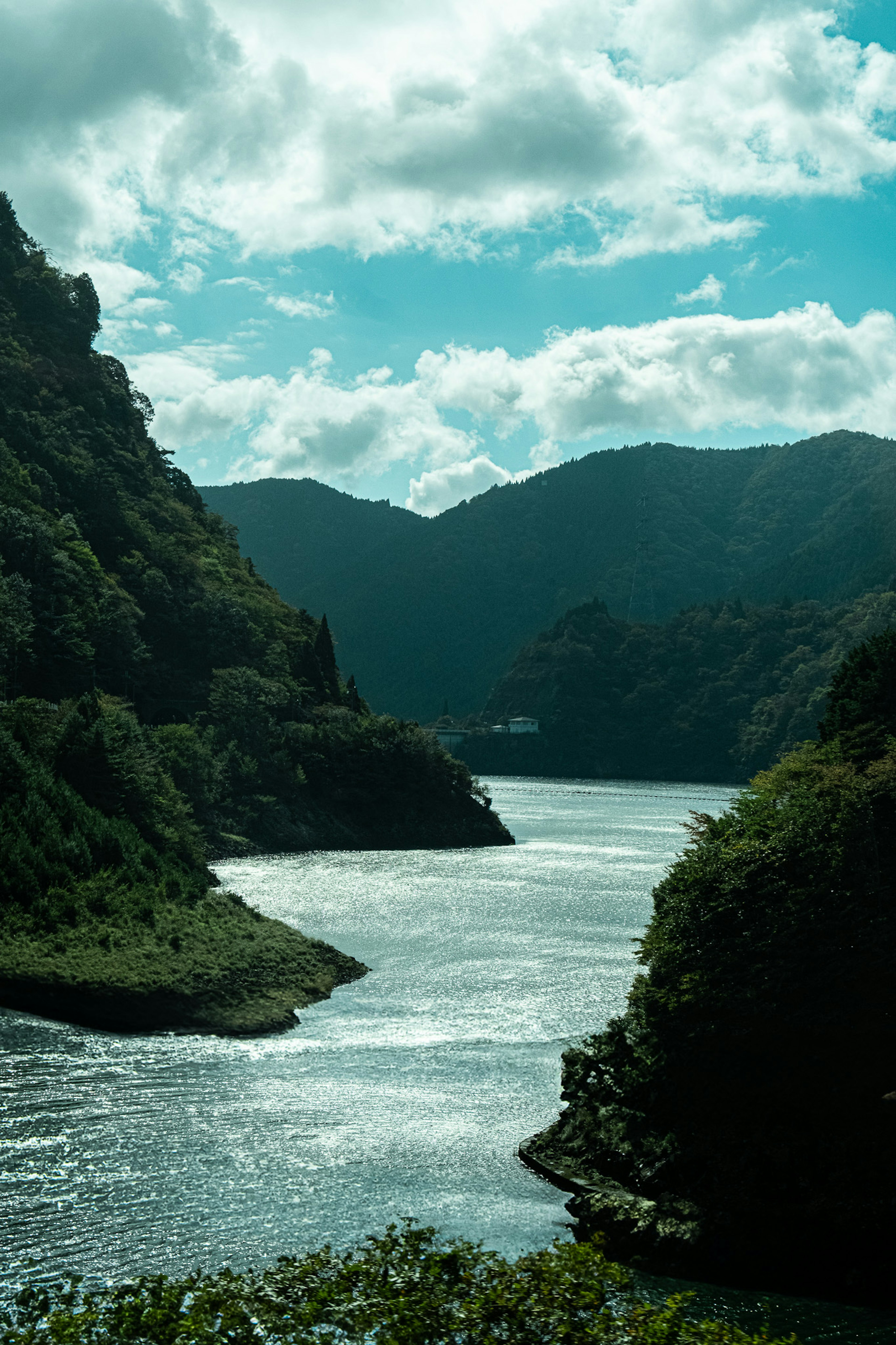 Vue panoramique d'une rivière serpentant à travers des montagnes sous un ciel nuageux