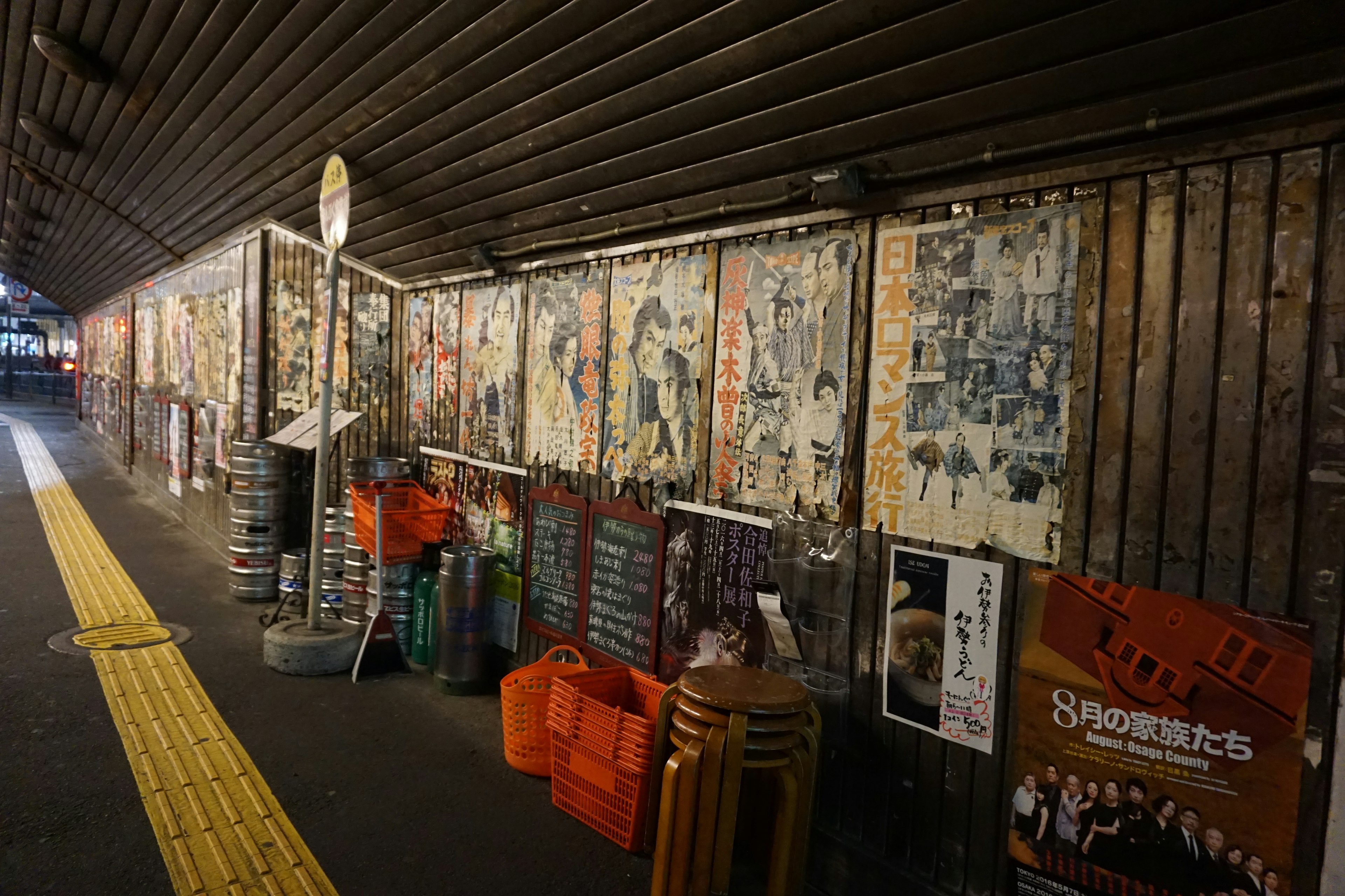 Muro coperto di manifesti vintage e pubblicità in una stazione sotterranea