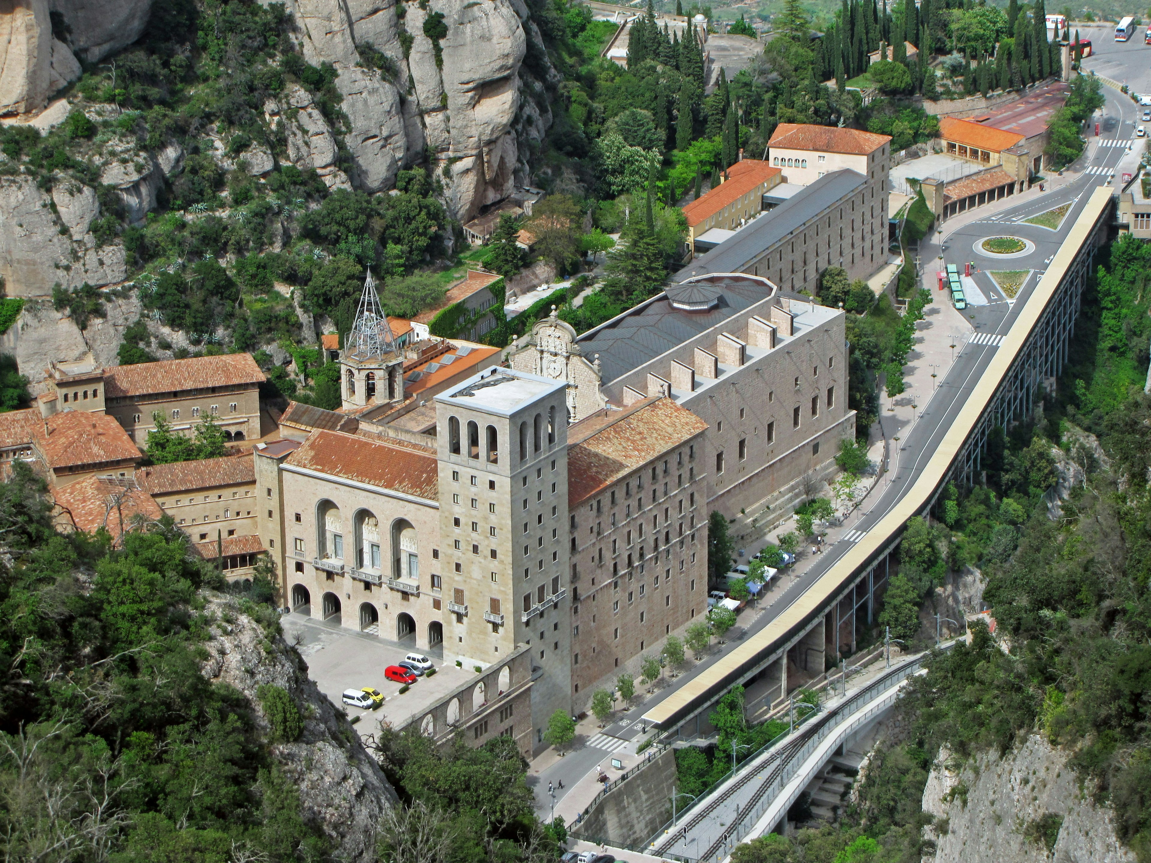 Aerial view of Montserrat Monastery showcasing lush green mountains and historical architecture