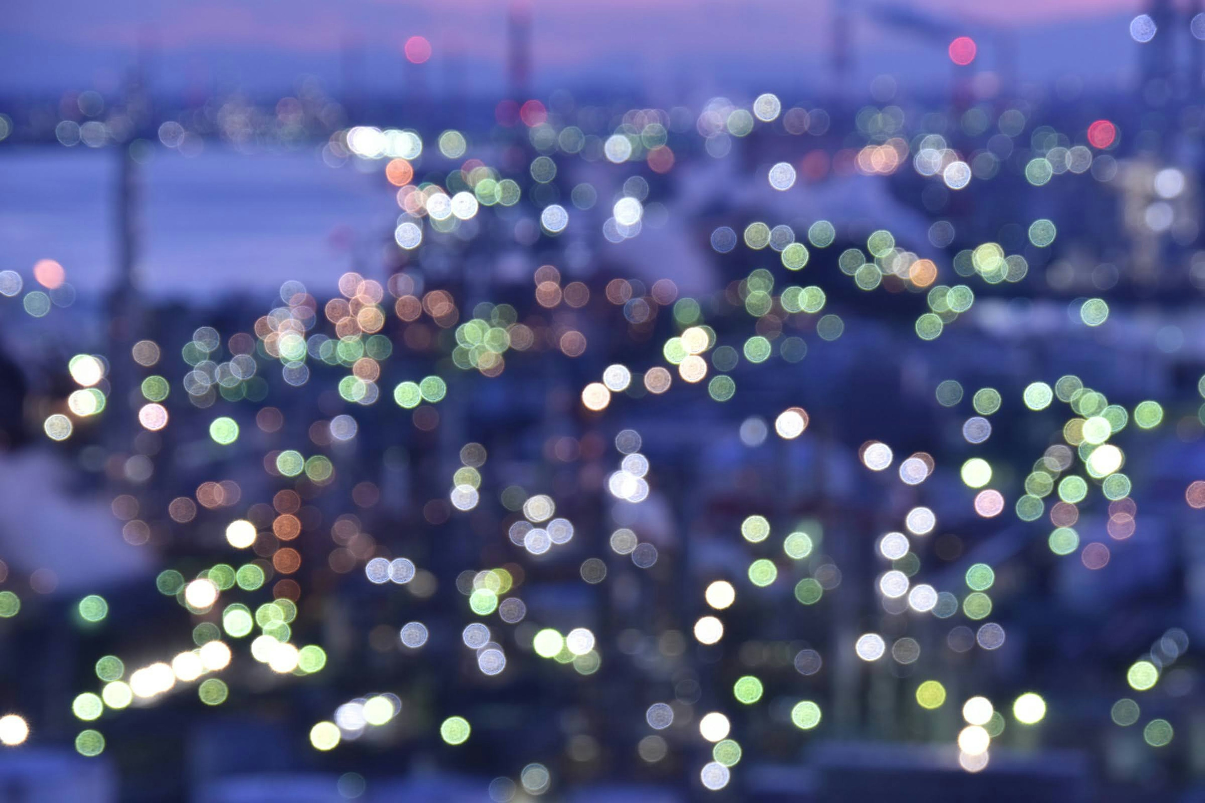 ぼやけた夜景の都市の光が点在する