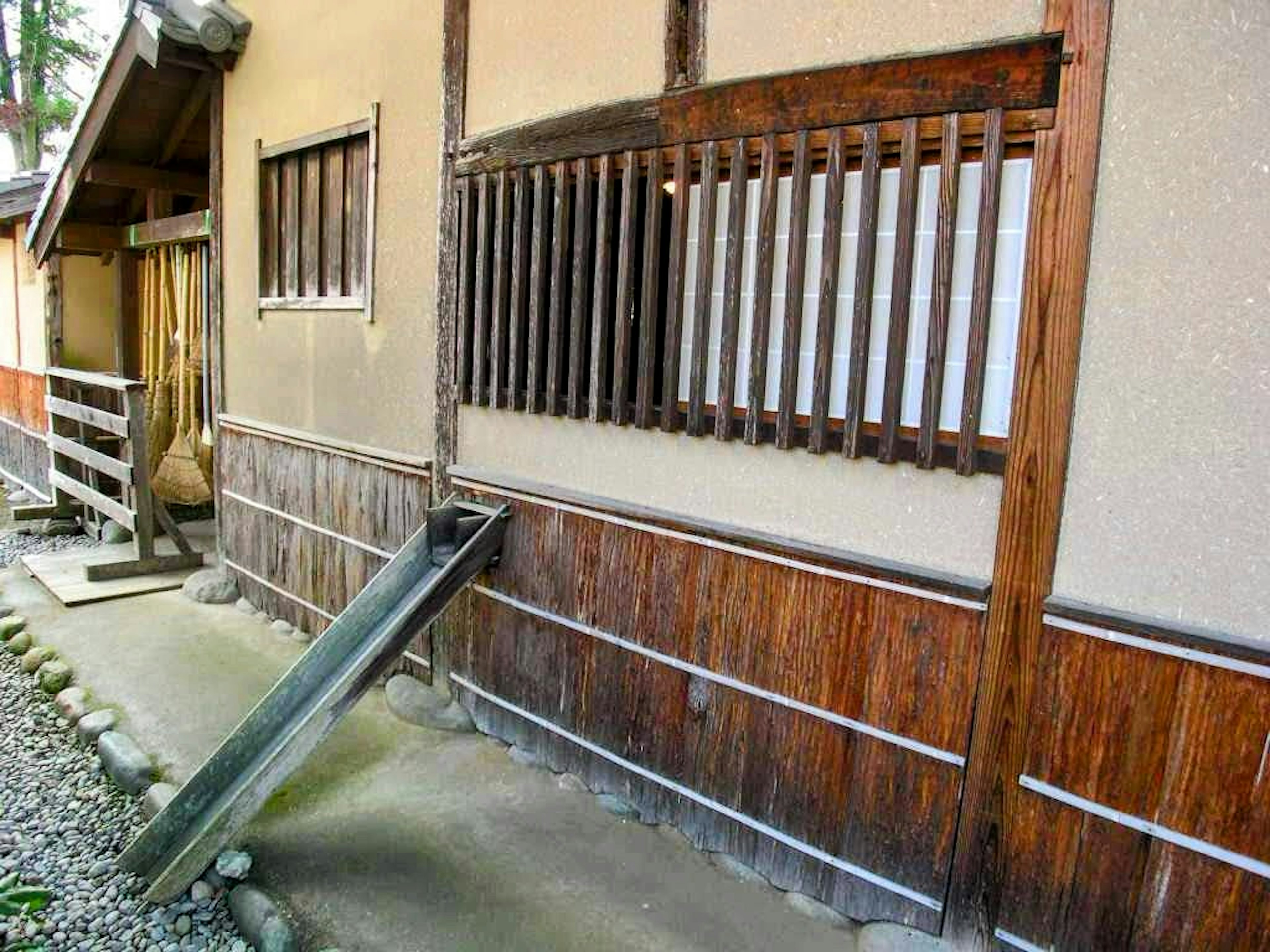 Exterior de una casa japonesa tradicional con ventanas de madera y diseño de pared de piedra