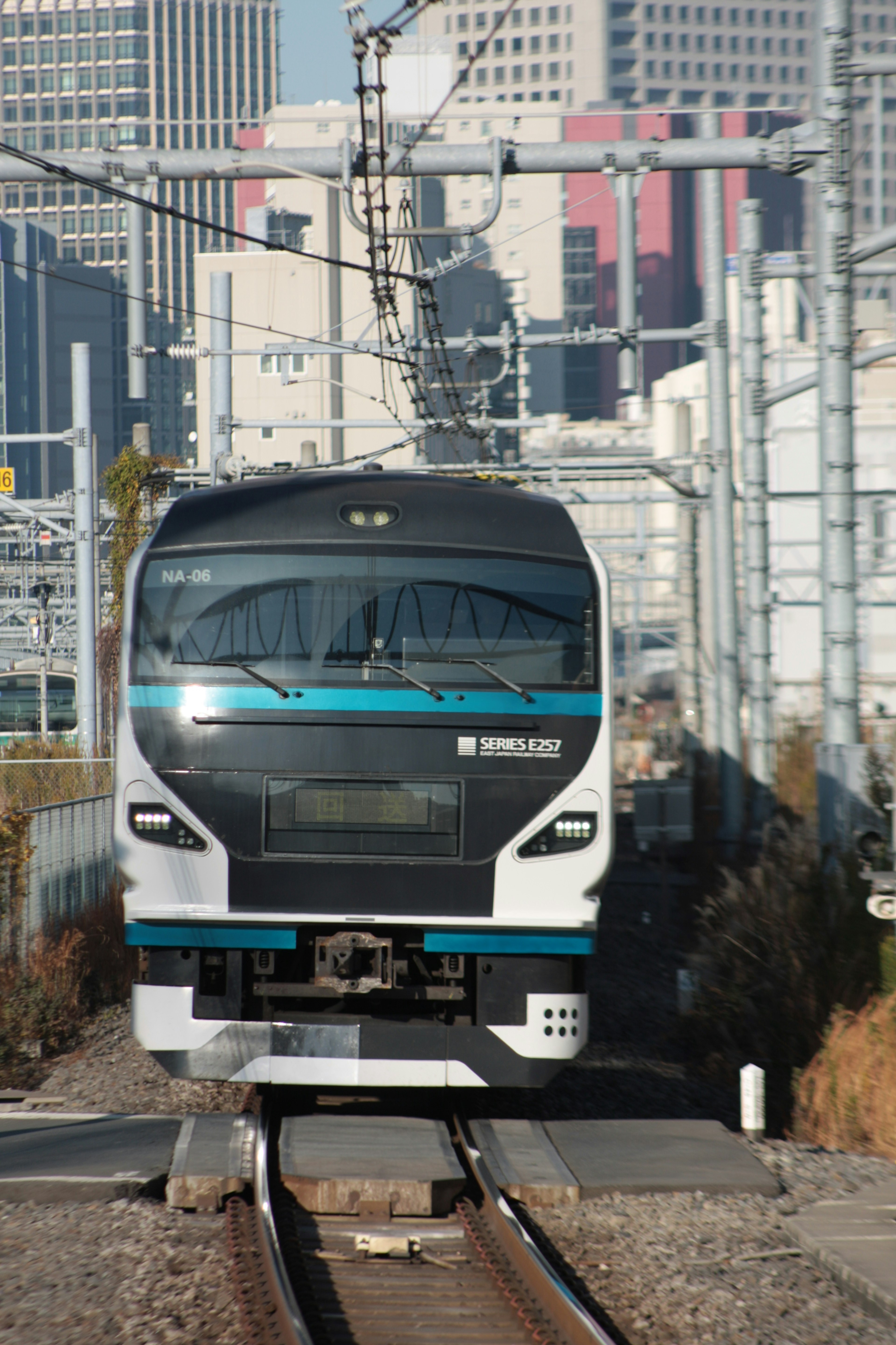 Un treno moderno che corre su binari con uno sfondo urbano