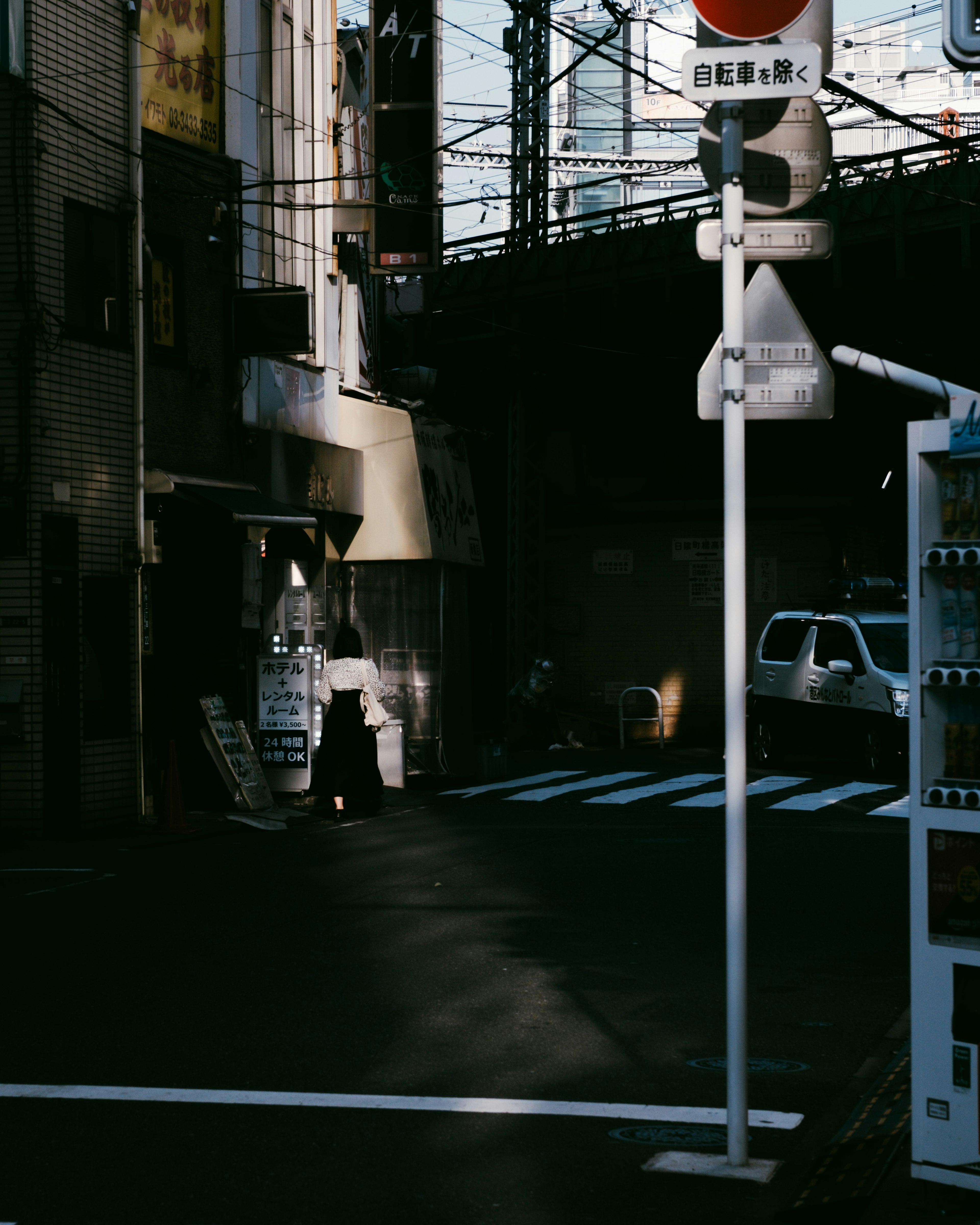 Traffic signal and vending machine at a dark street intersection