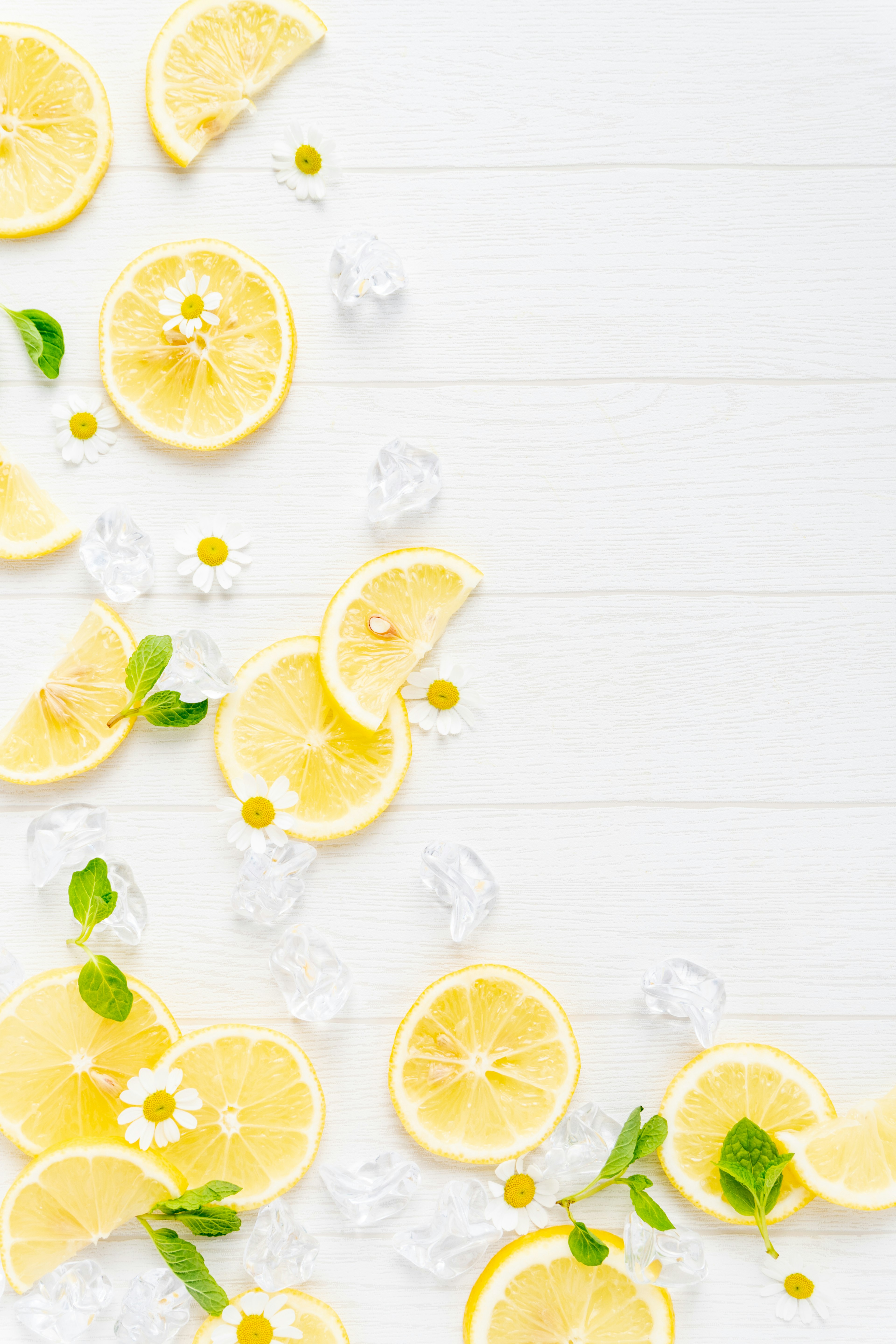 Immagine con fette di limone e foglie di menta sparse su uno sfondo bianco