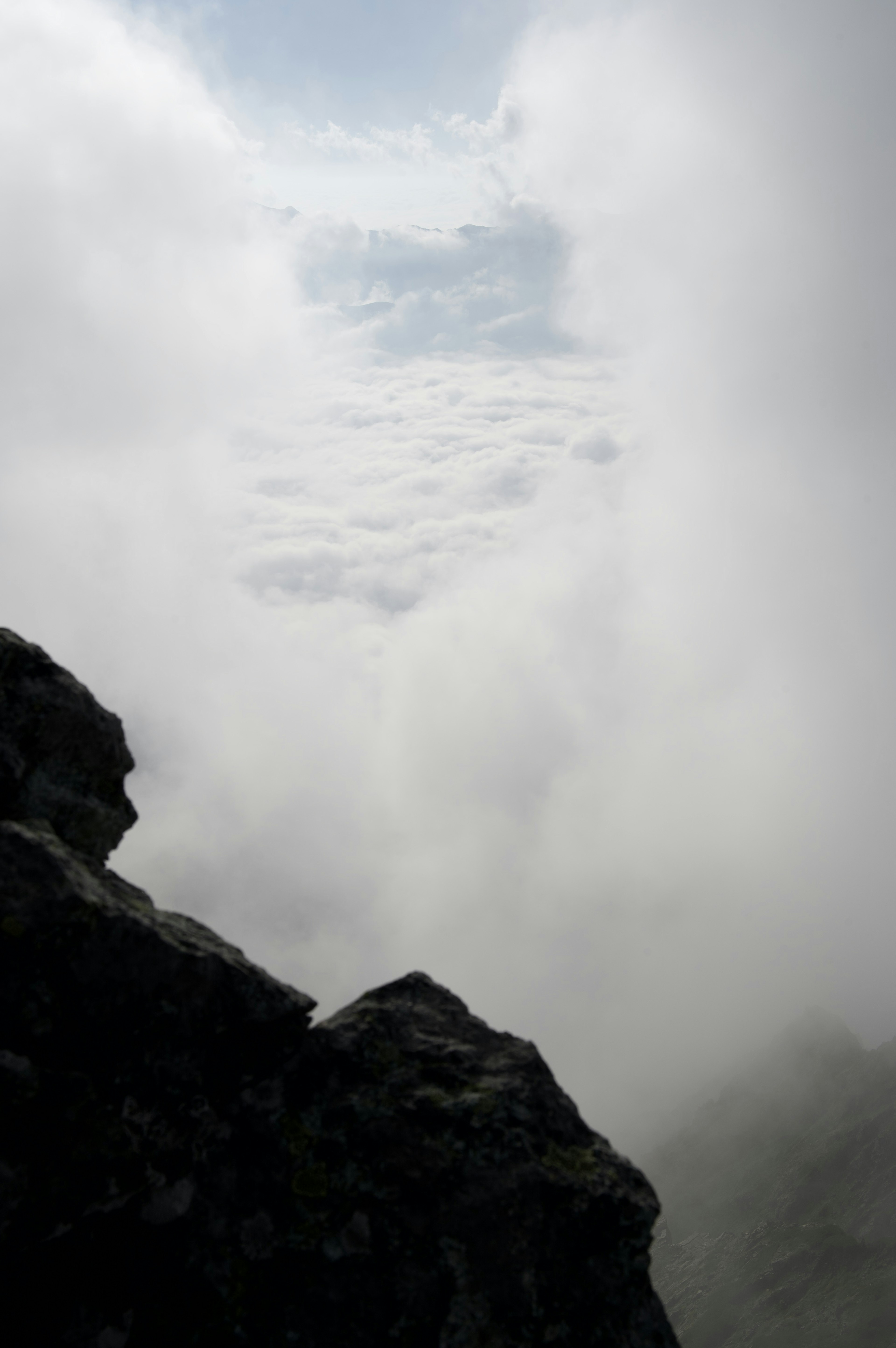 雲の間から見える山の景色と岩