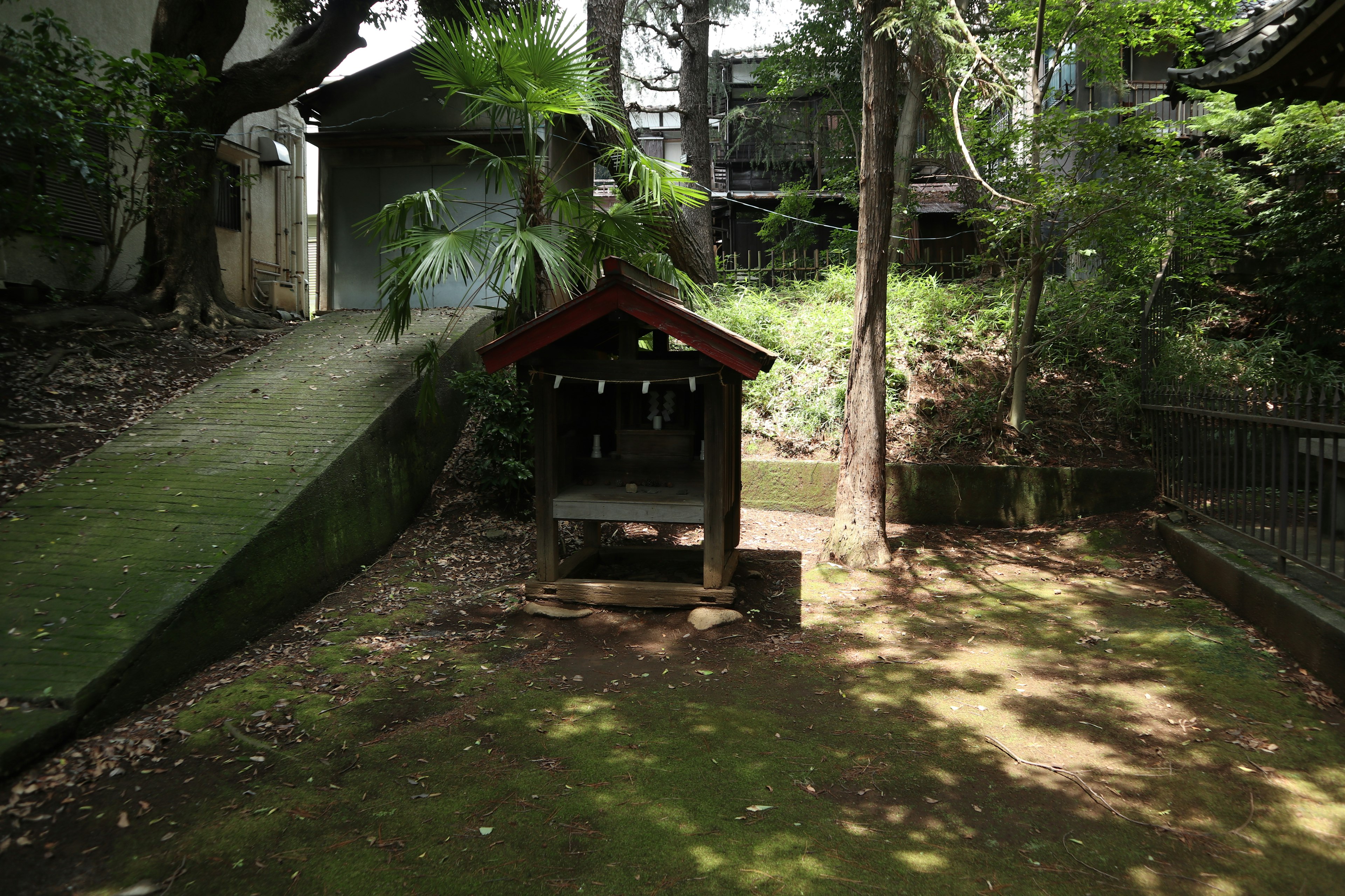 宁静的场景，绿意盎然的花园里有小屋和石凳