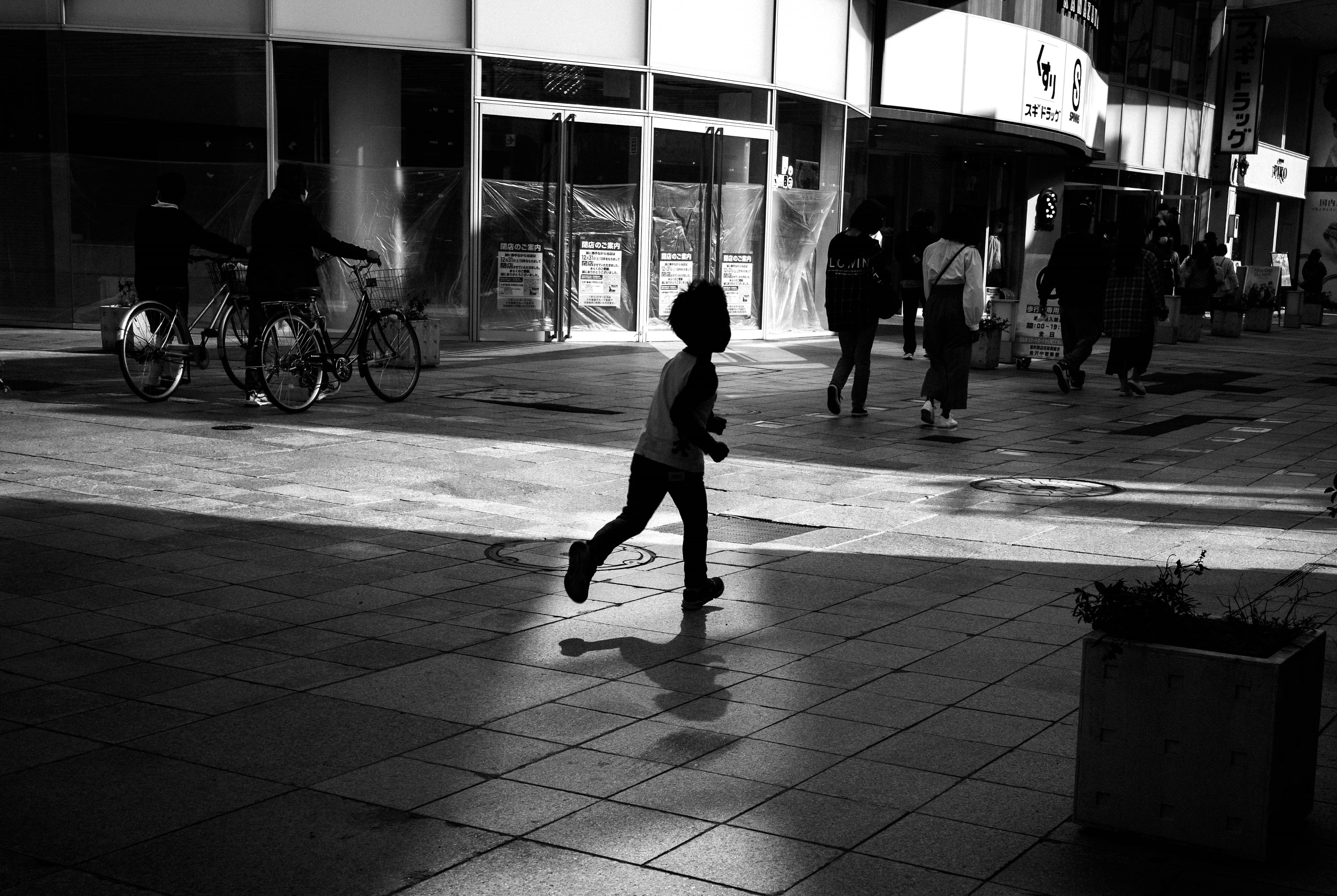 Bambino che corre in una strada di città in bianco e nero