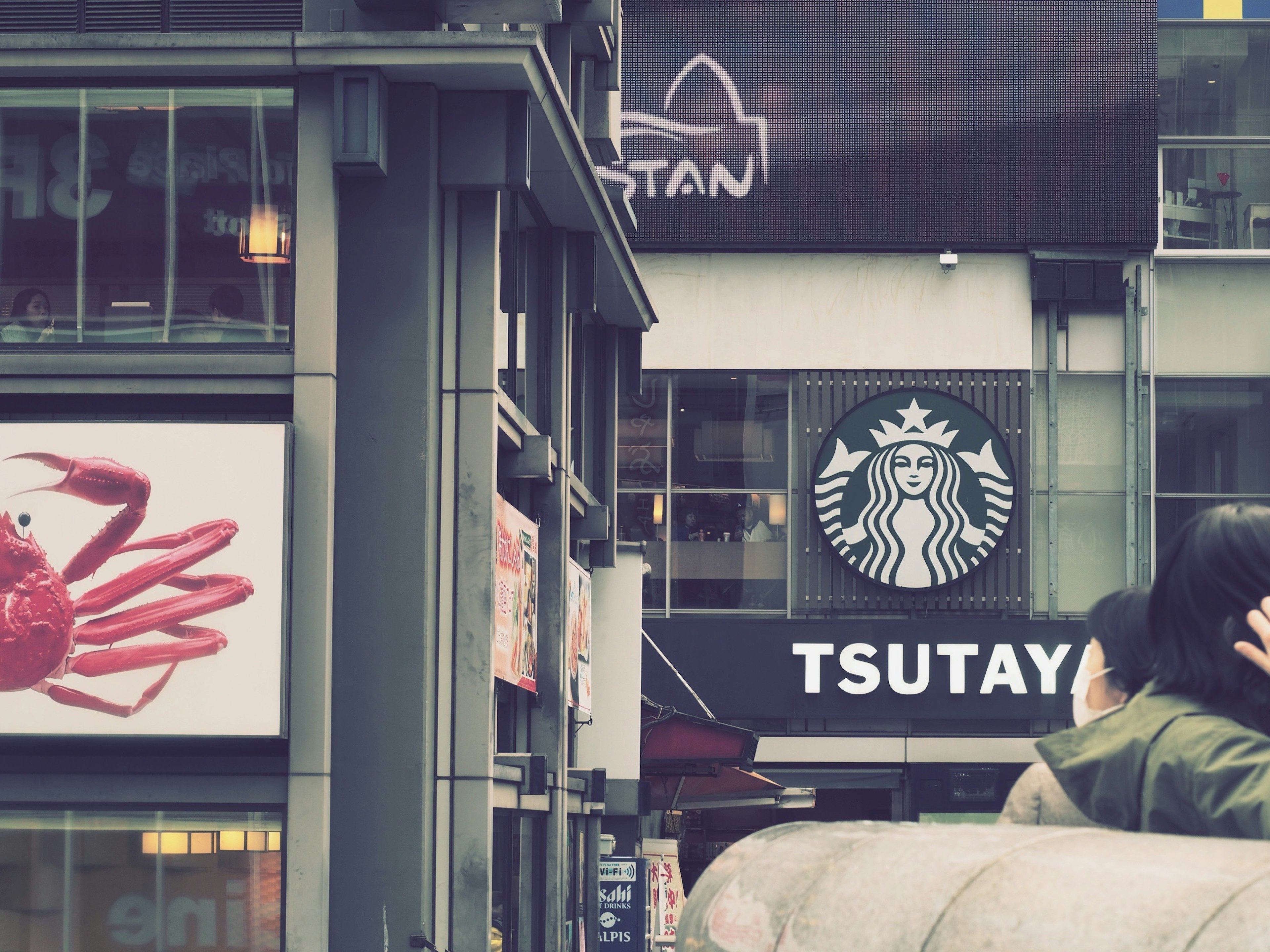 Vista di un angolo di strada con insegna TSUTAYA e logo Starbucks