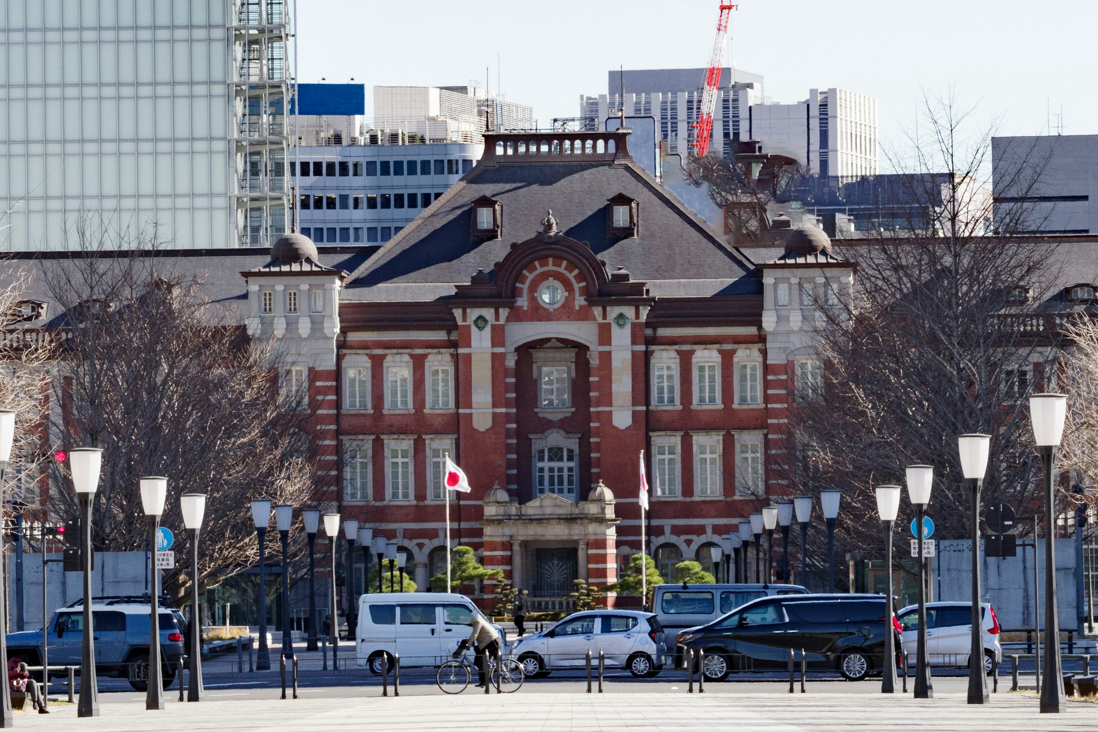 Bangunan bata Stasiun Tokyo dengan gedung pencakar langit modern di latar belakang