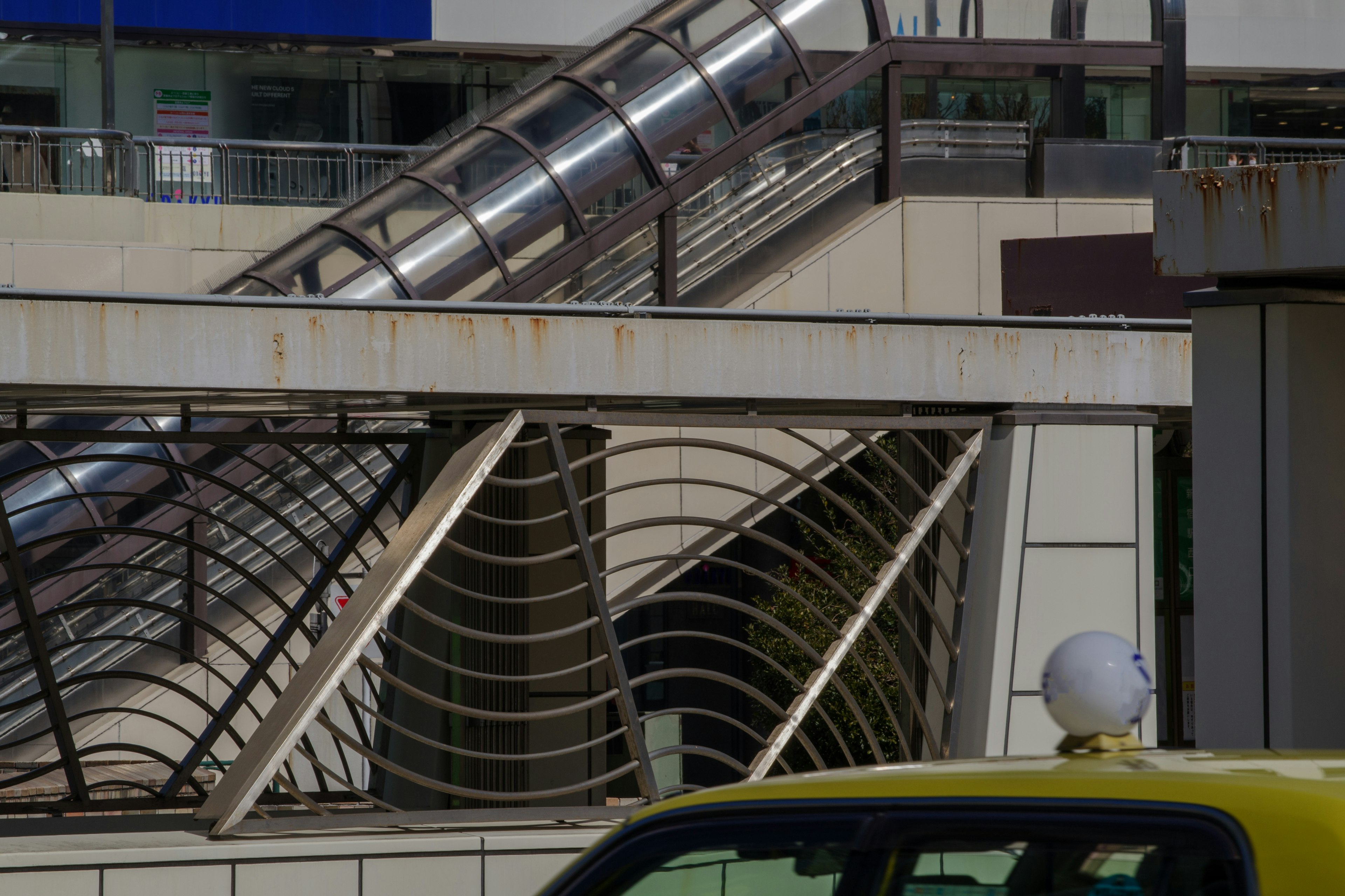 Imagen que presenta parte de un edificio de la ciudad y un taxi diseño metálico distintivo y escaleras