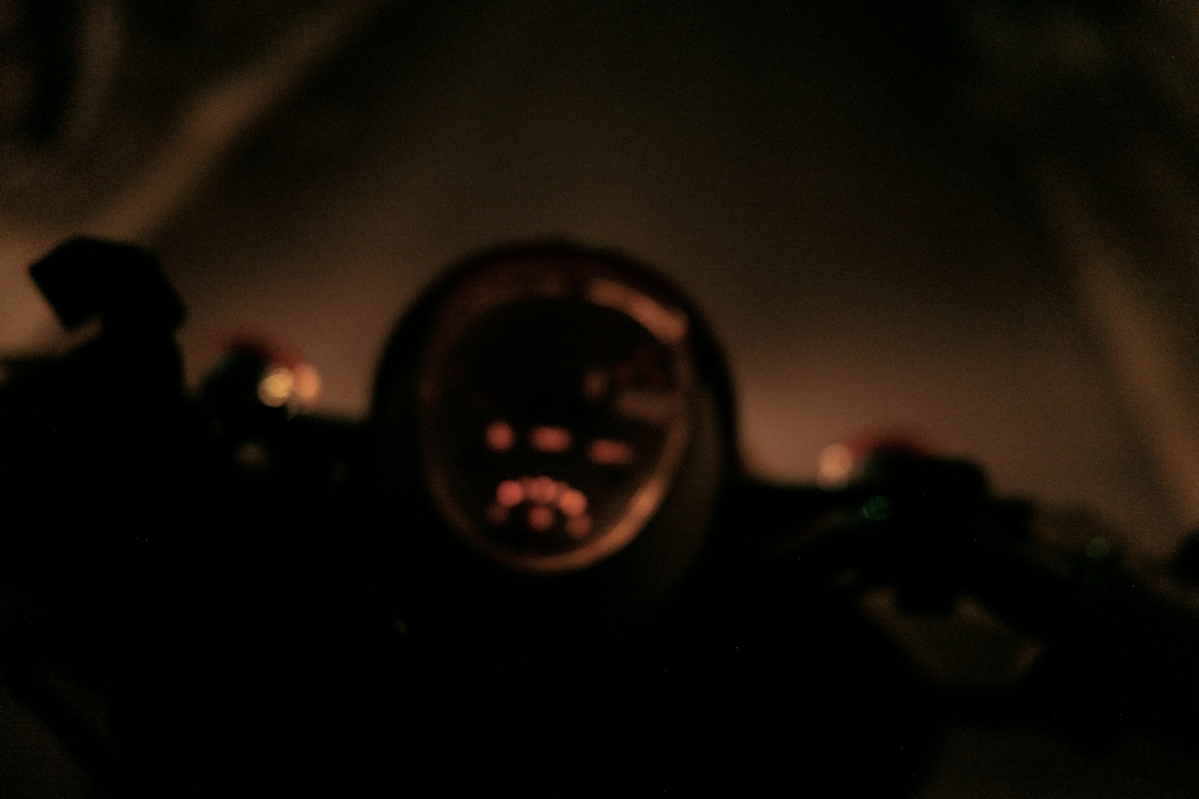 Close-up of a motorcycle dashboard at night with orange light