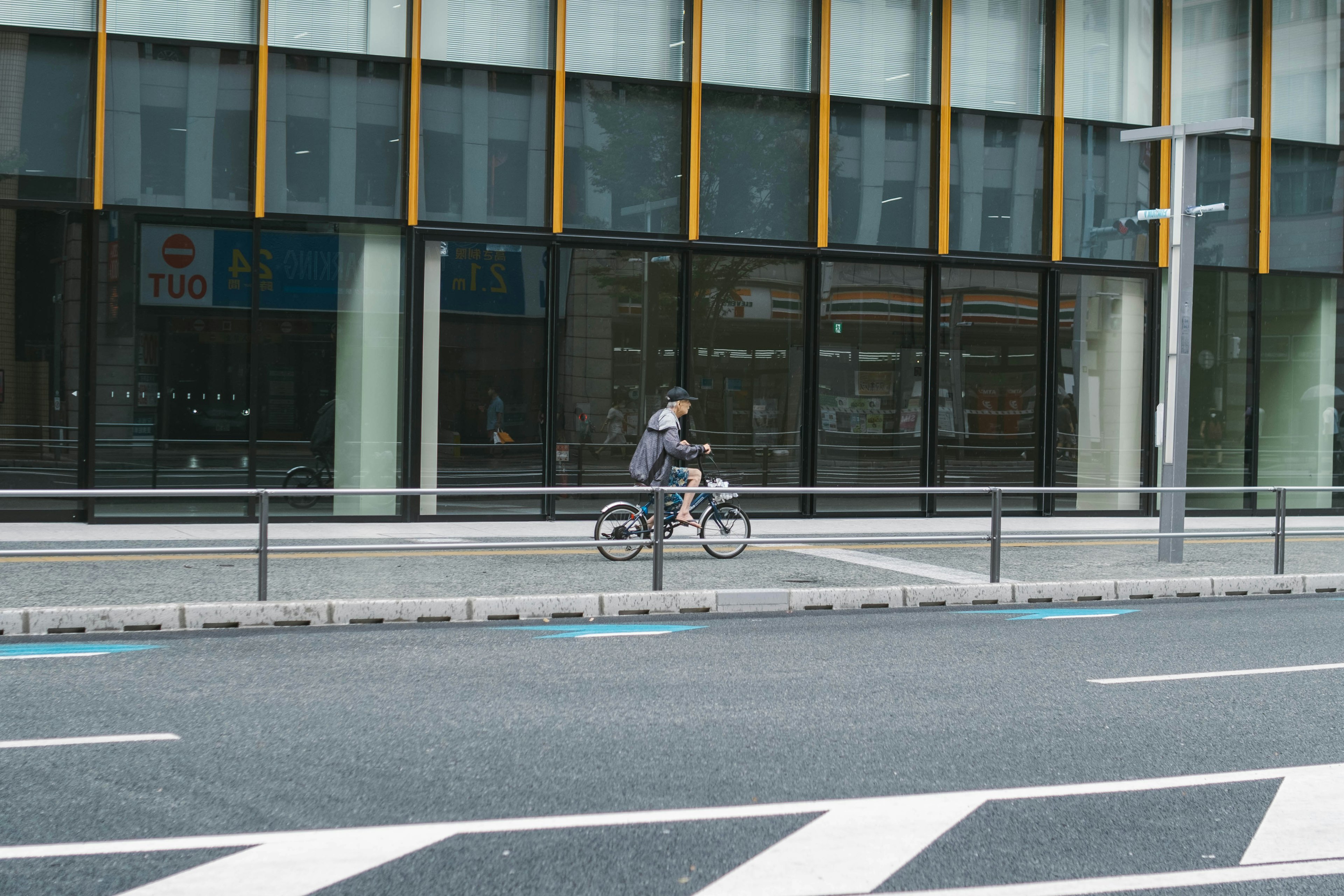 Un hombre montando en bicicleta frente a un edificio moderno