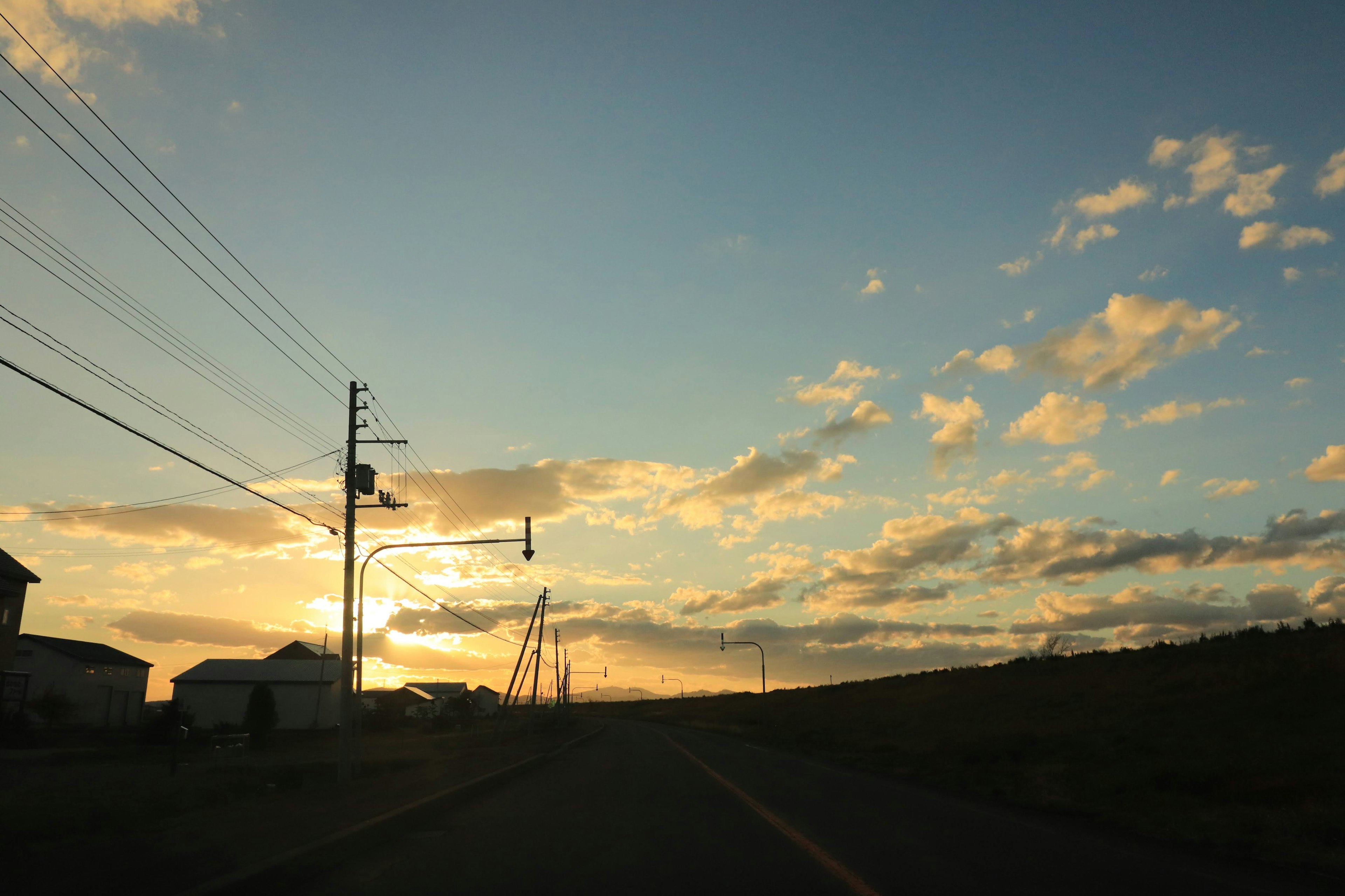 Coucher de soleil sur une route rurale avec des nuages épars