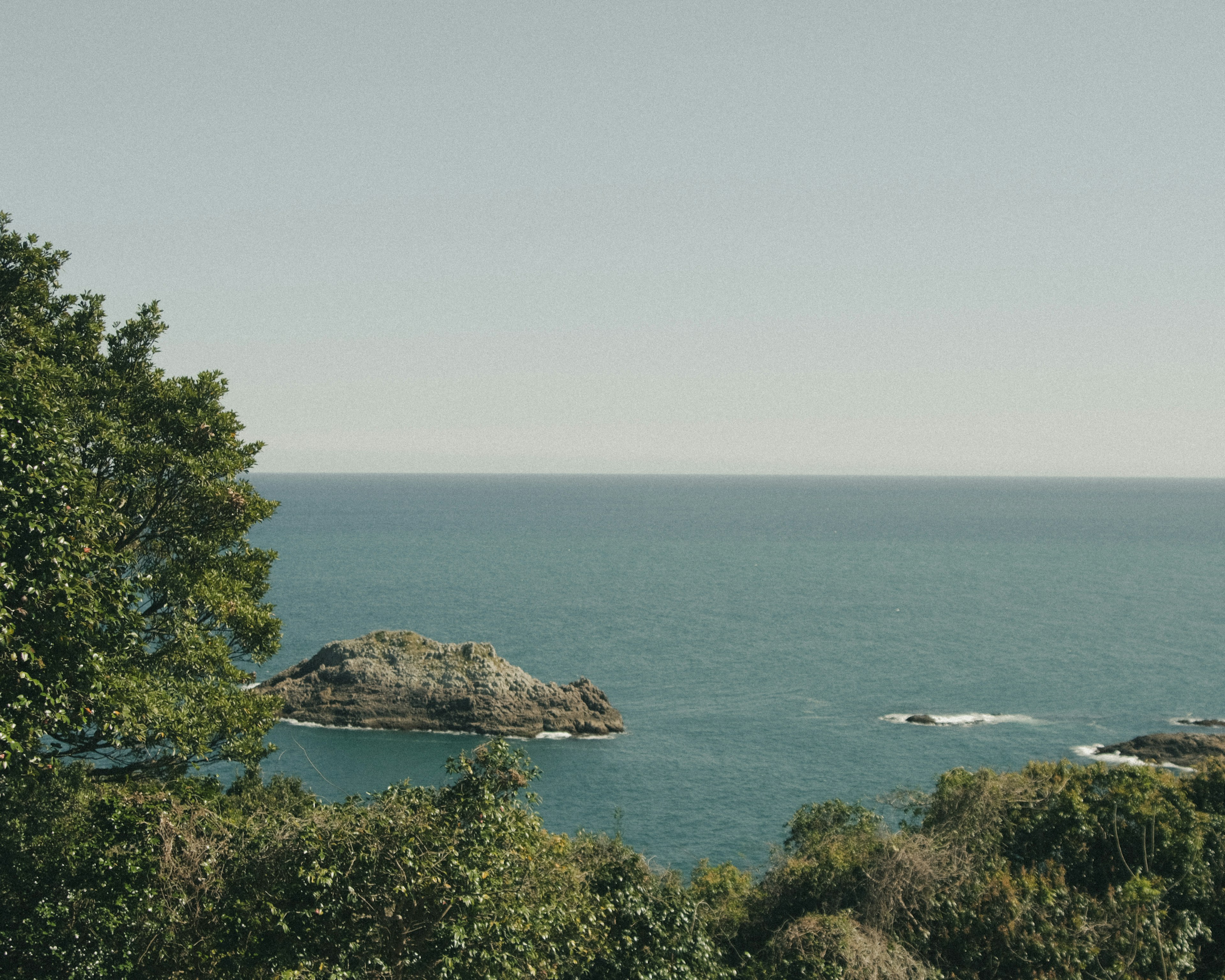 Natural landscape featuring blue sea and rocky outcrop