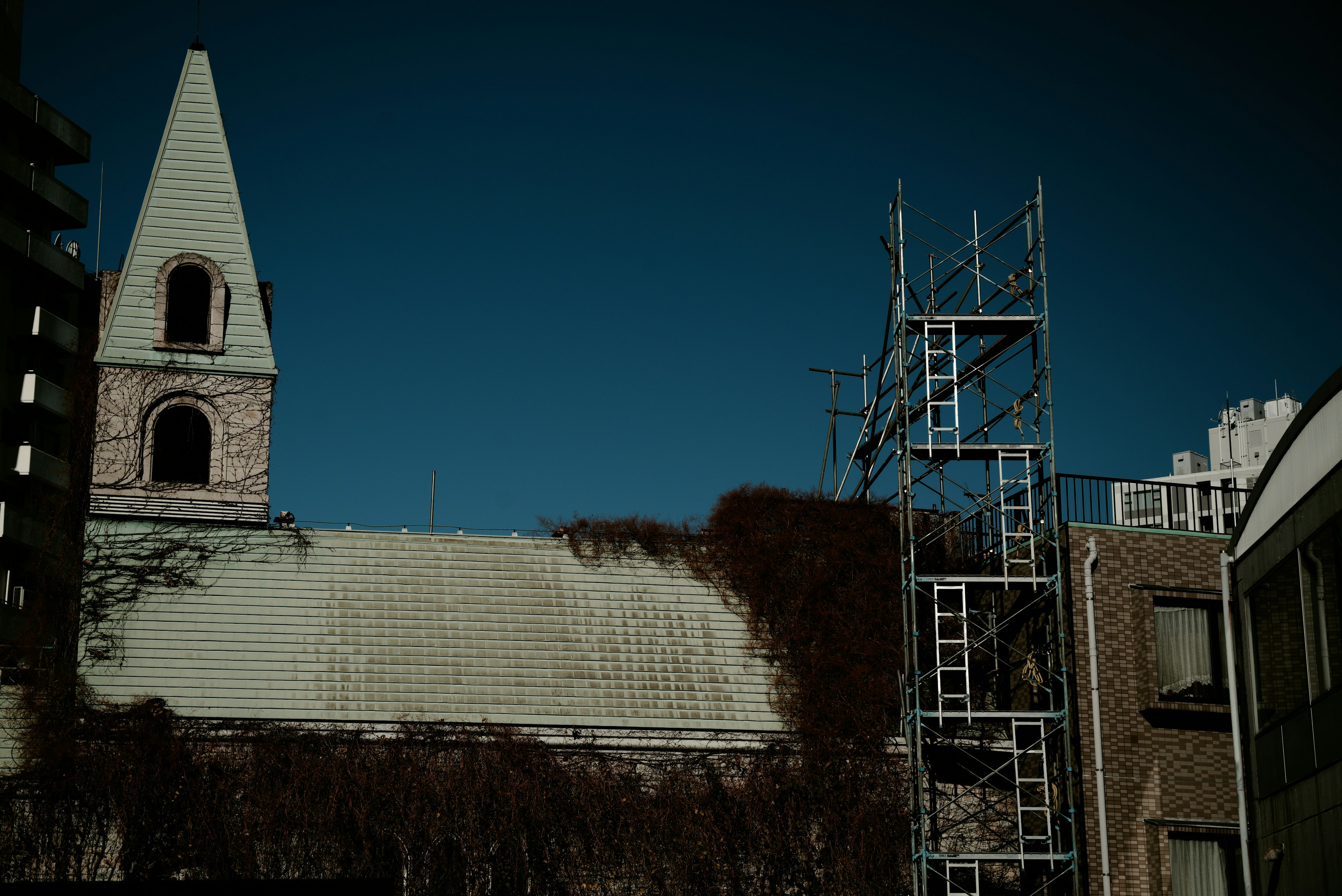 Vue d'un vieux clocher d'église et d'un échafaudage sur un bâtiment