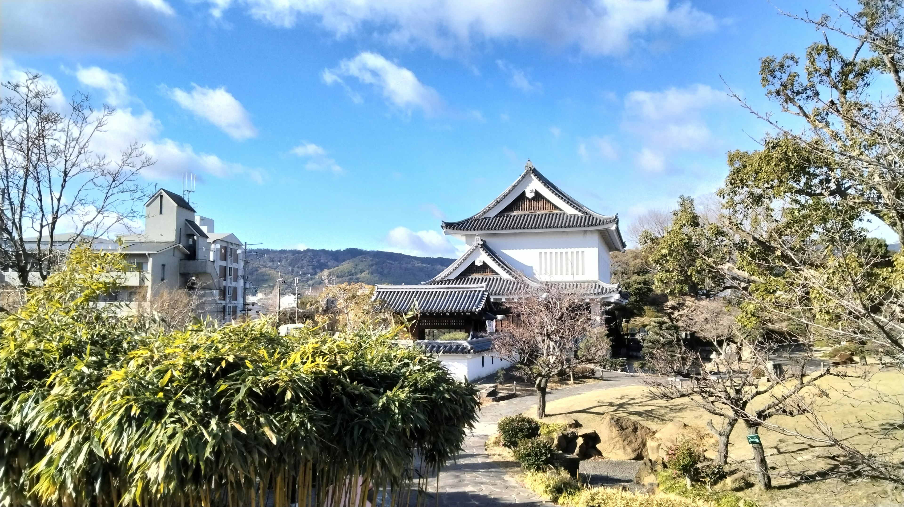 Traditionelle japanische Schloss- und Gartenlandschaft unter blauem Himmel