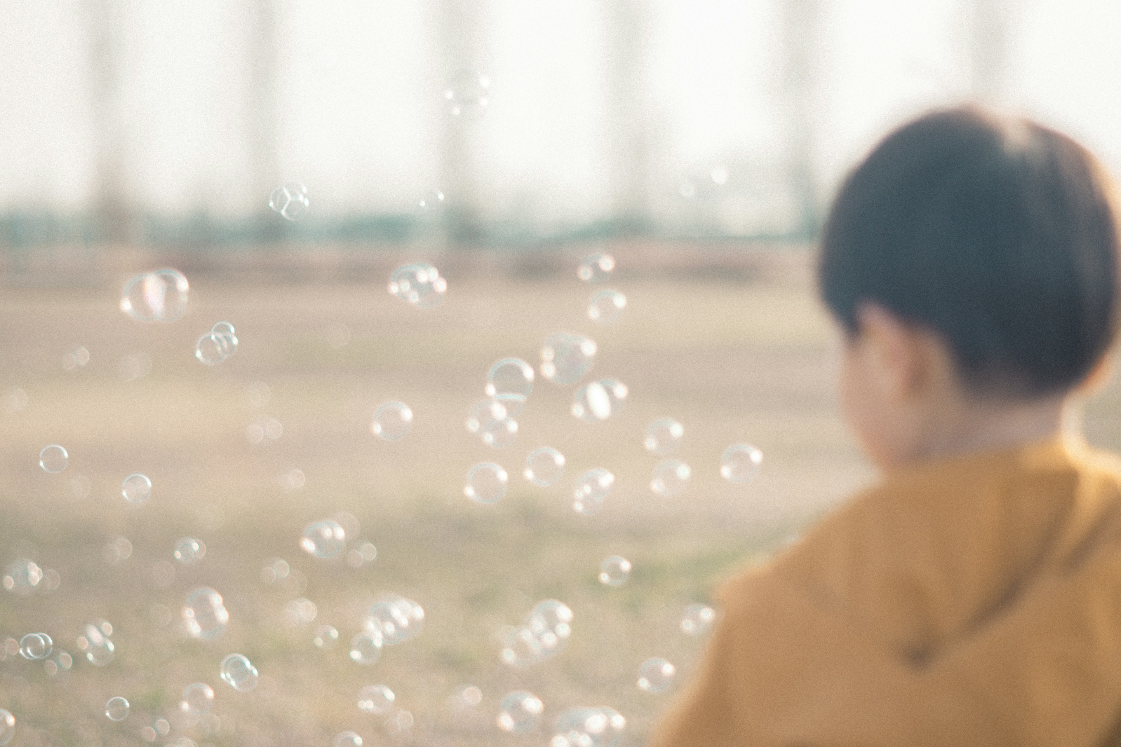 Un enfant jouant parmi des bulles avec un arrière-plan flou