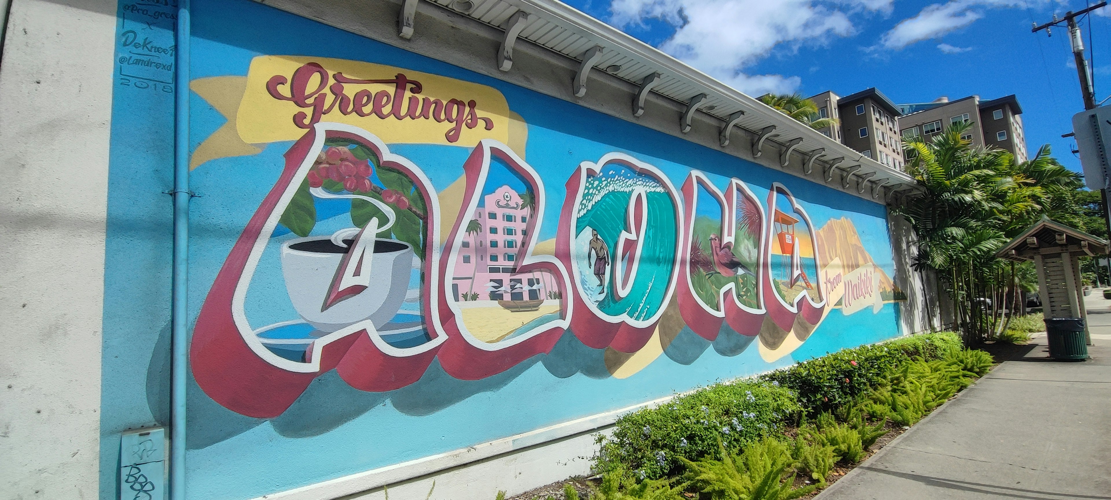 A colorful mural featuring the word Aloha in a Hawaiian setting