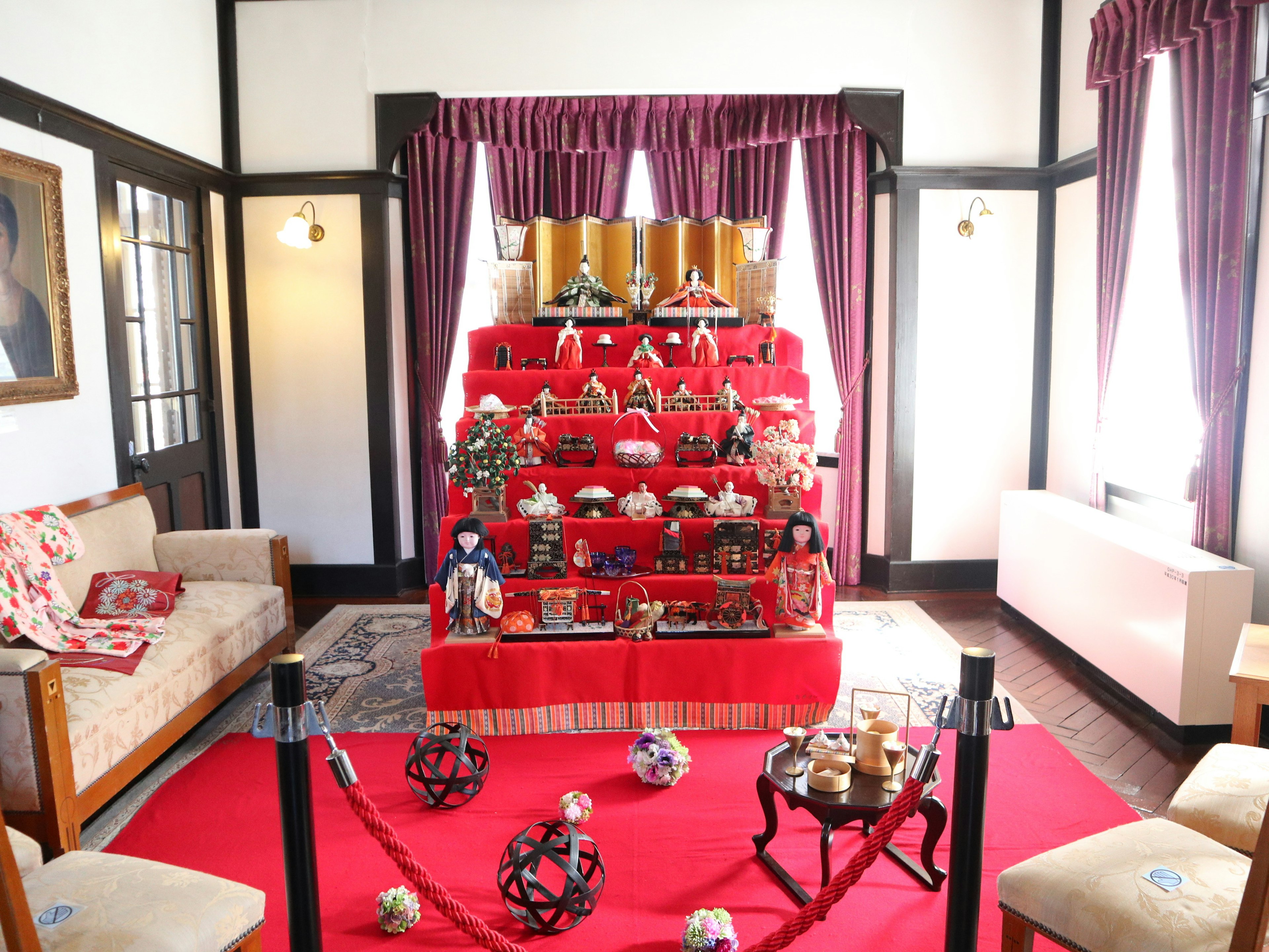 Interior of a room featuring a display of hina dolls on a red carpet