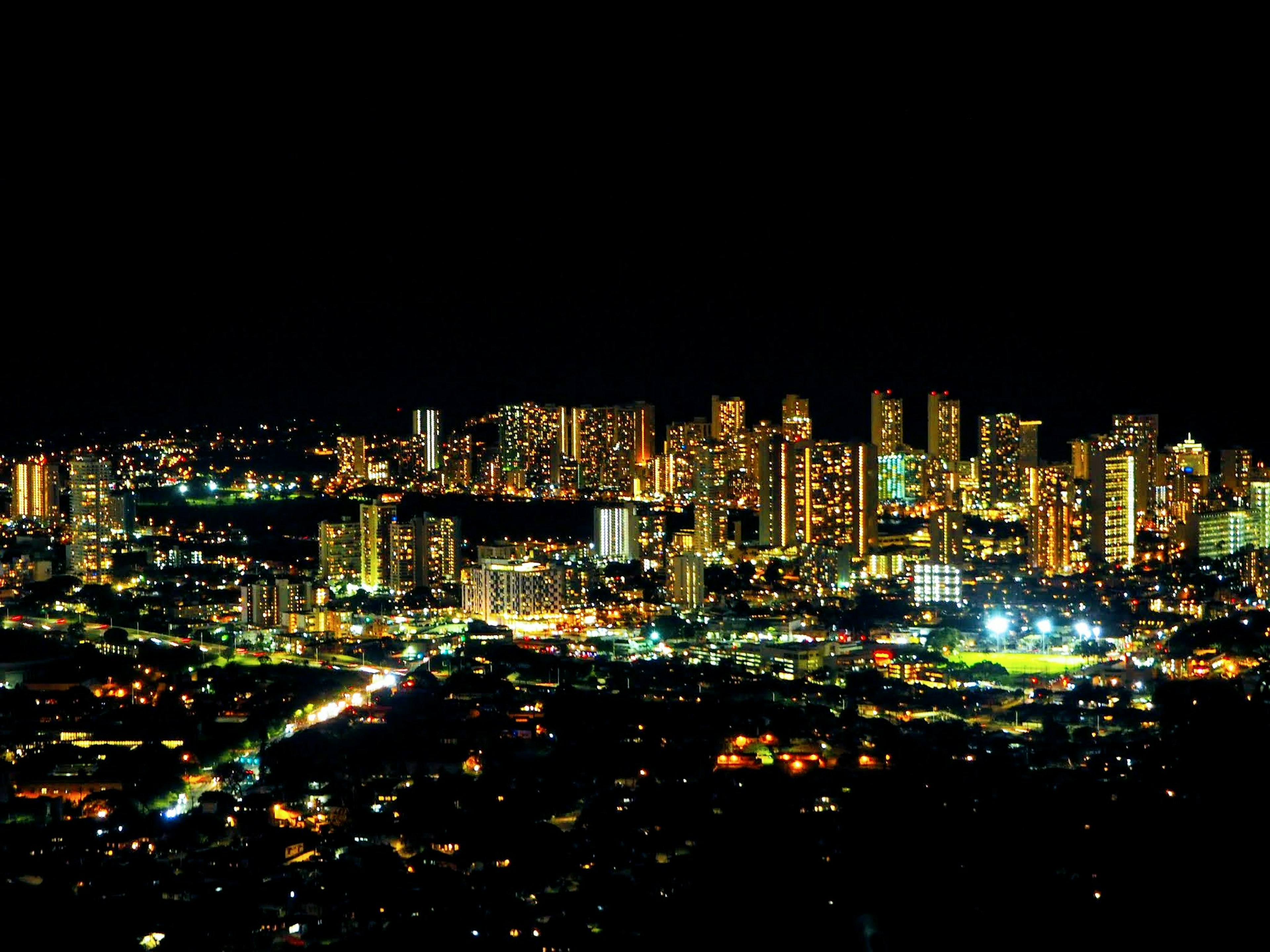 Panoramablick auf eine Stadt mit beleuchteten Wolkenkratzern bei Nacht