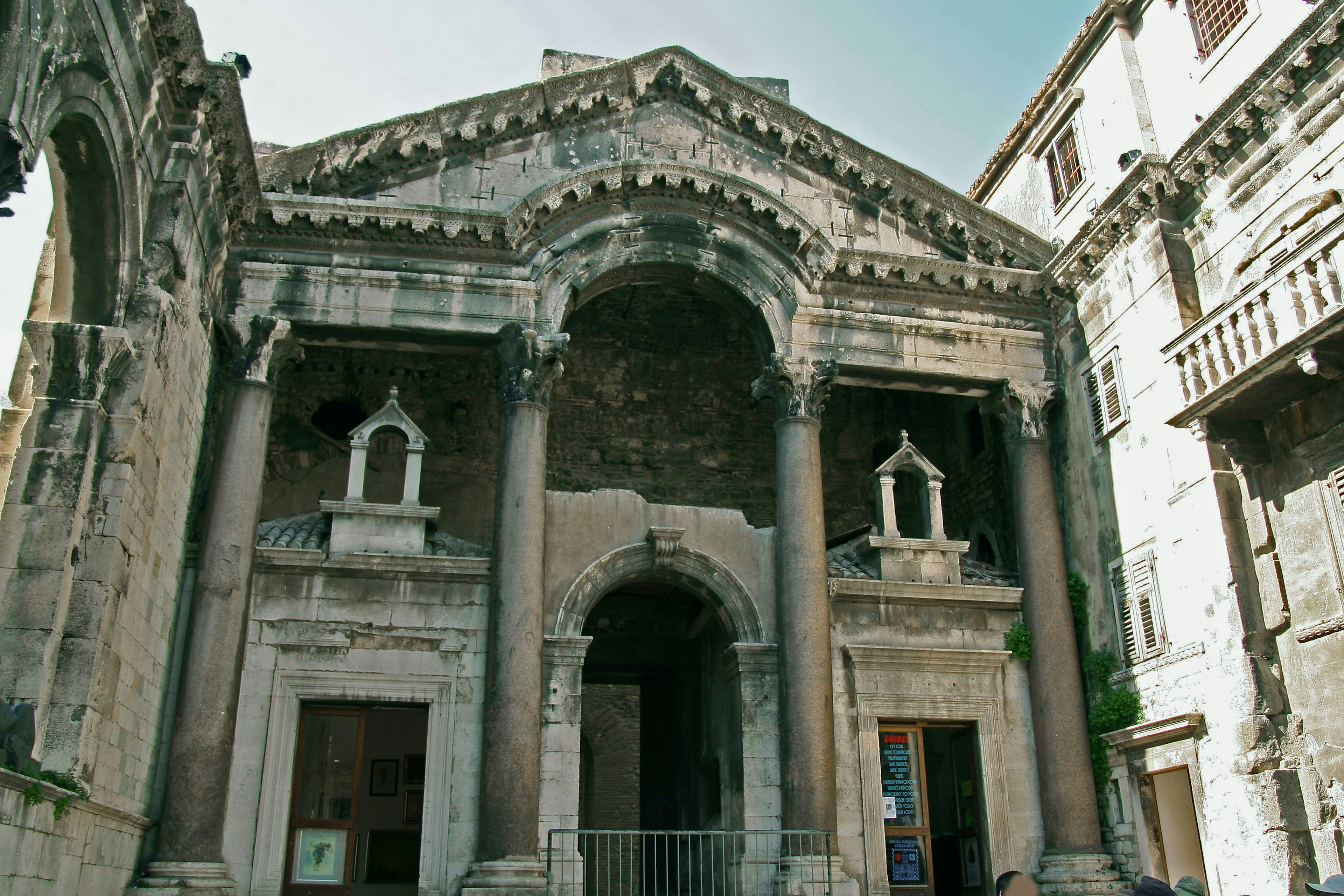 Historic building facade featuring ancient sculptures and arched entrance