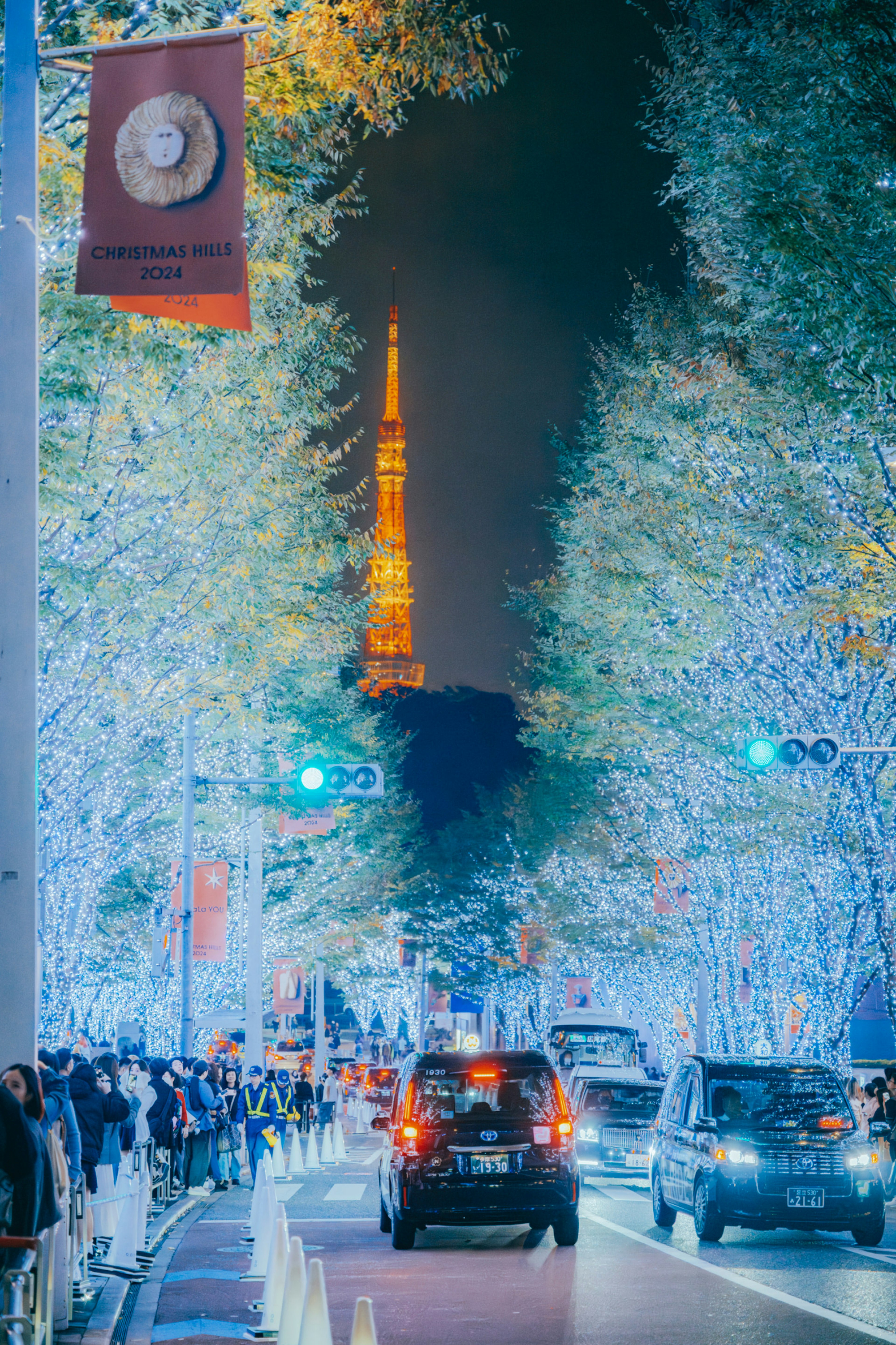 Tokyoturm nachts beleuchtet mit festlichen Lichtern und belebter Straße